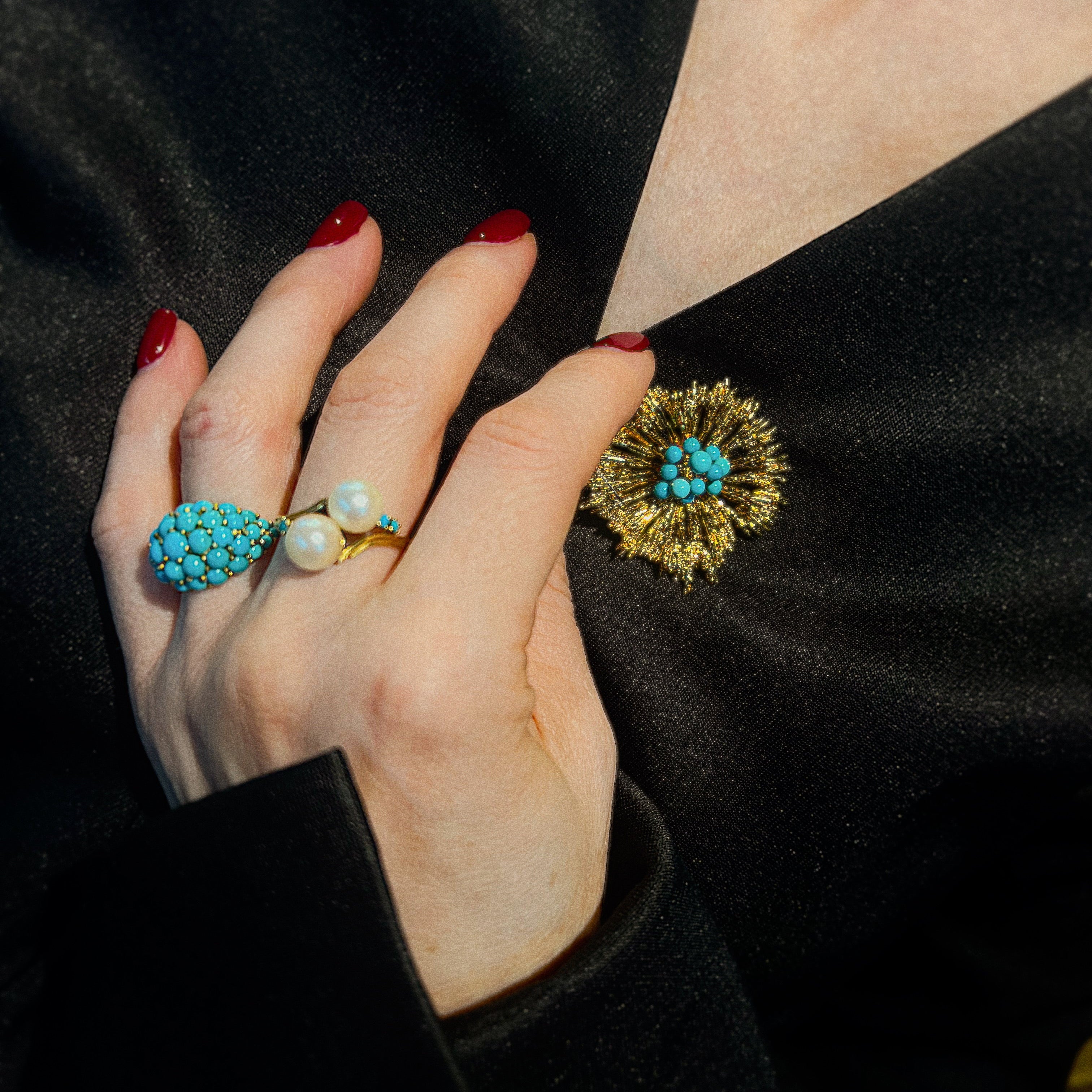Model wearing the styled vintage brutalist gold brooch with turquoise colored beads.