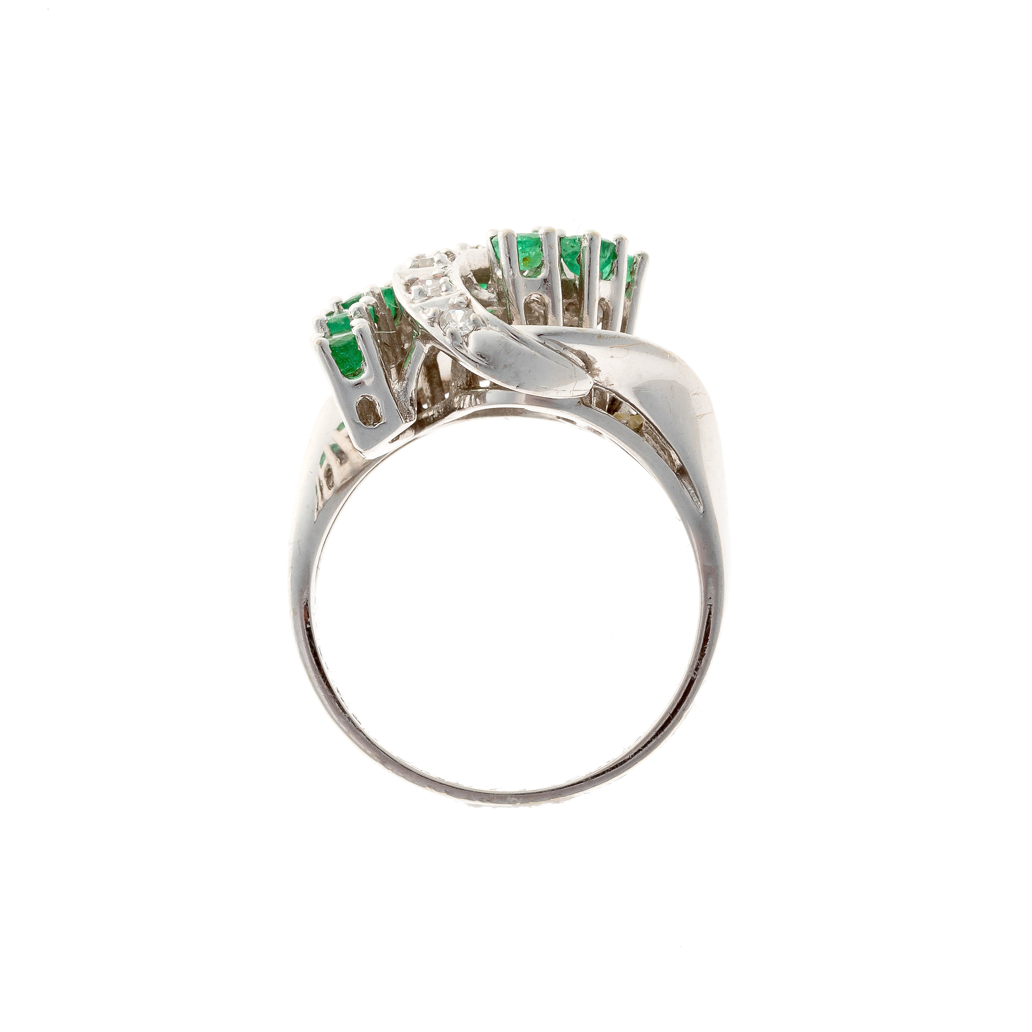 Profile of 1960s white gold ring with sculptural emerald and diamond swirl design.