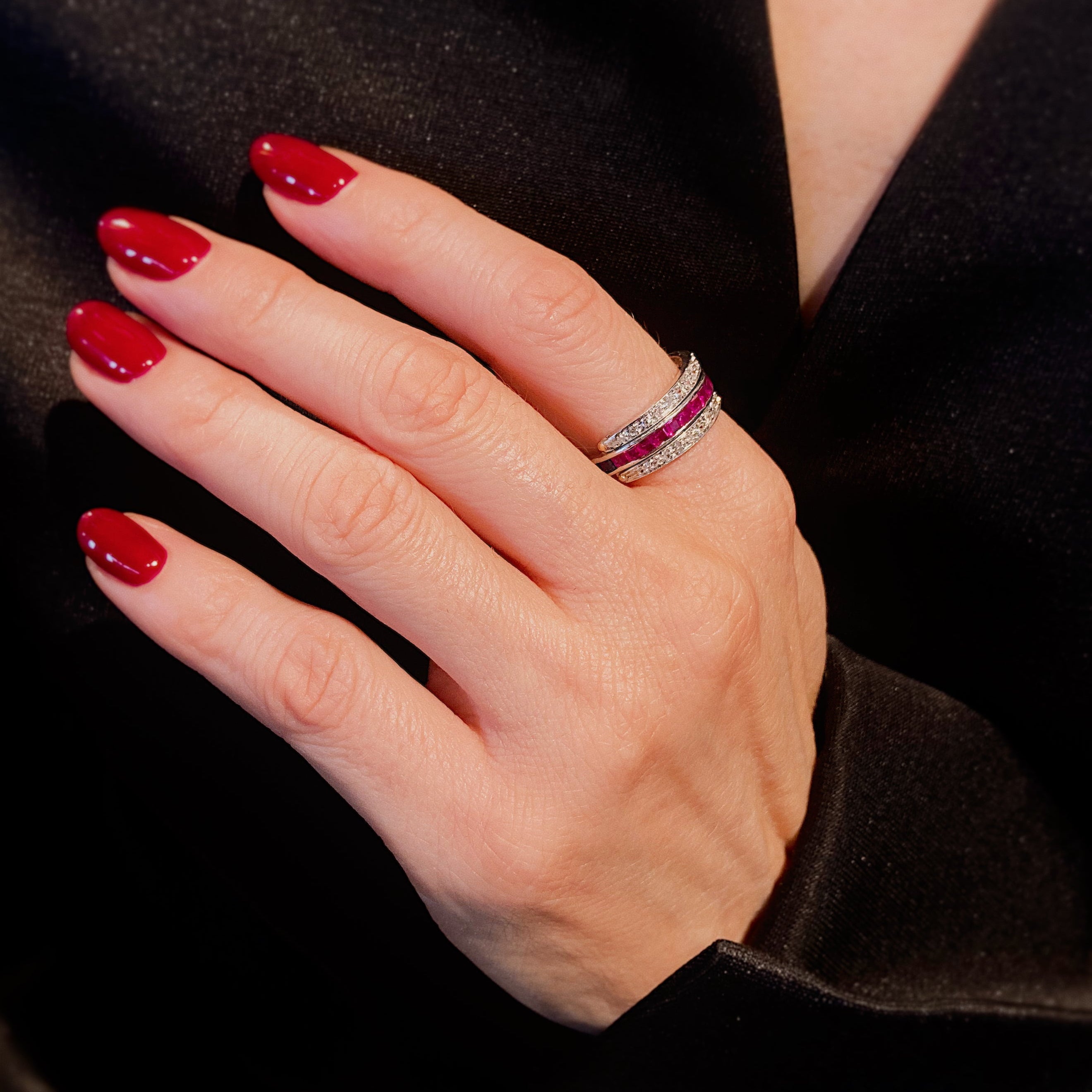Woman wearing the Art Deco platinum convertible double band ring with rubies, sapphires, and diamonds.