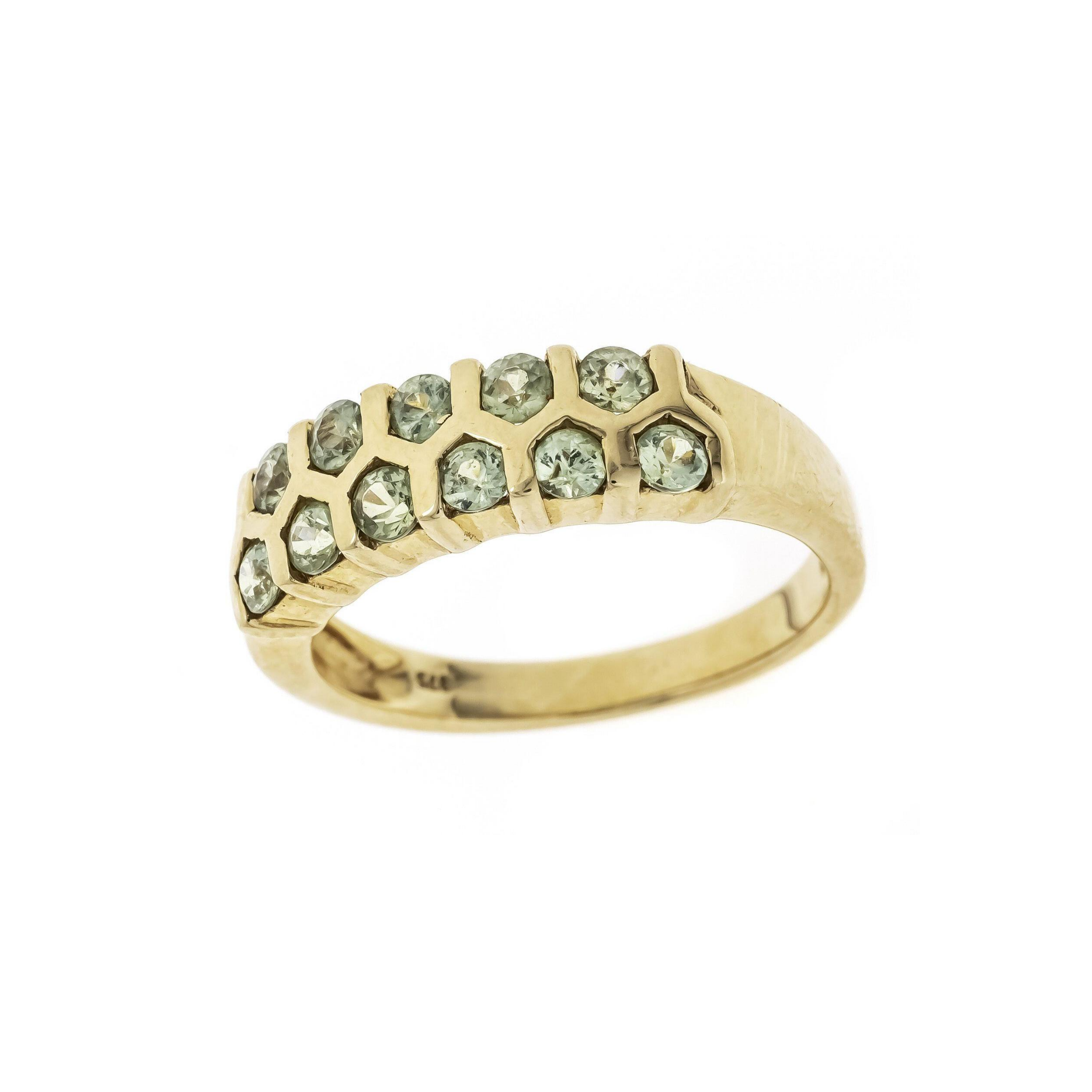 Brutalist honeycomb peridot ring in 9K gold, angled view showcasing geometric setting and vivid green gemstones.