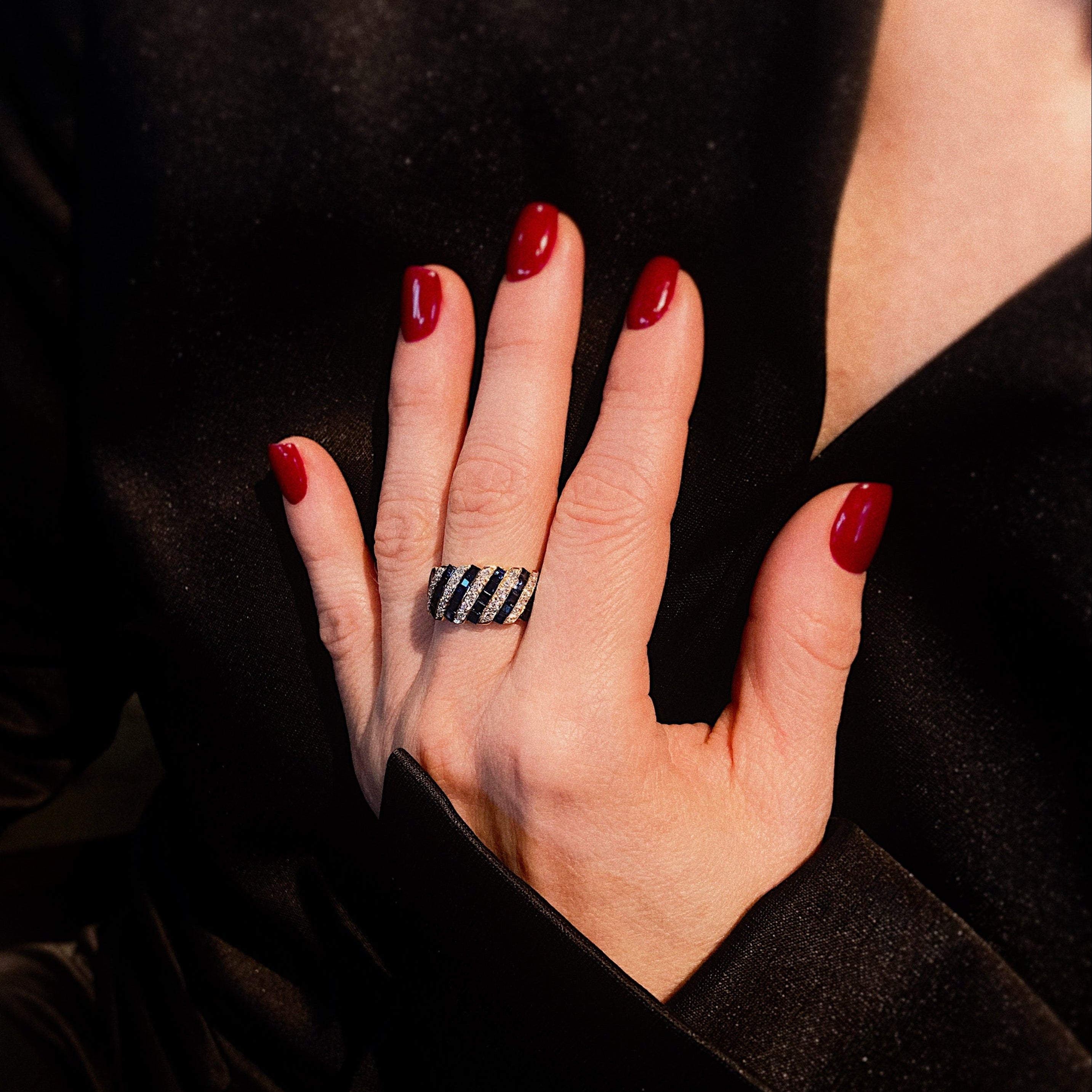 Model wearing the vintage gold cocktail ring with carre-cut diamonds and sapphires.