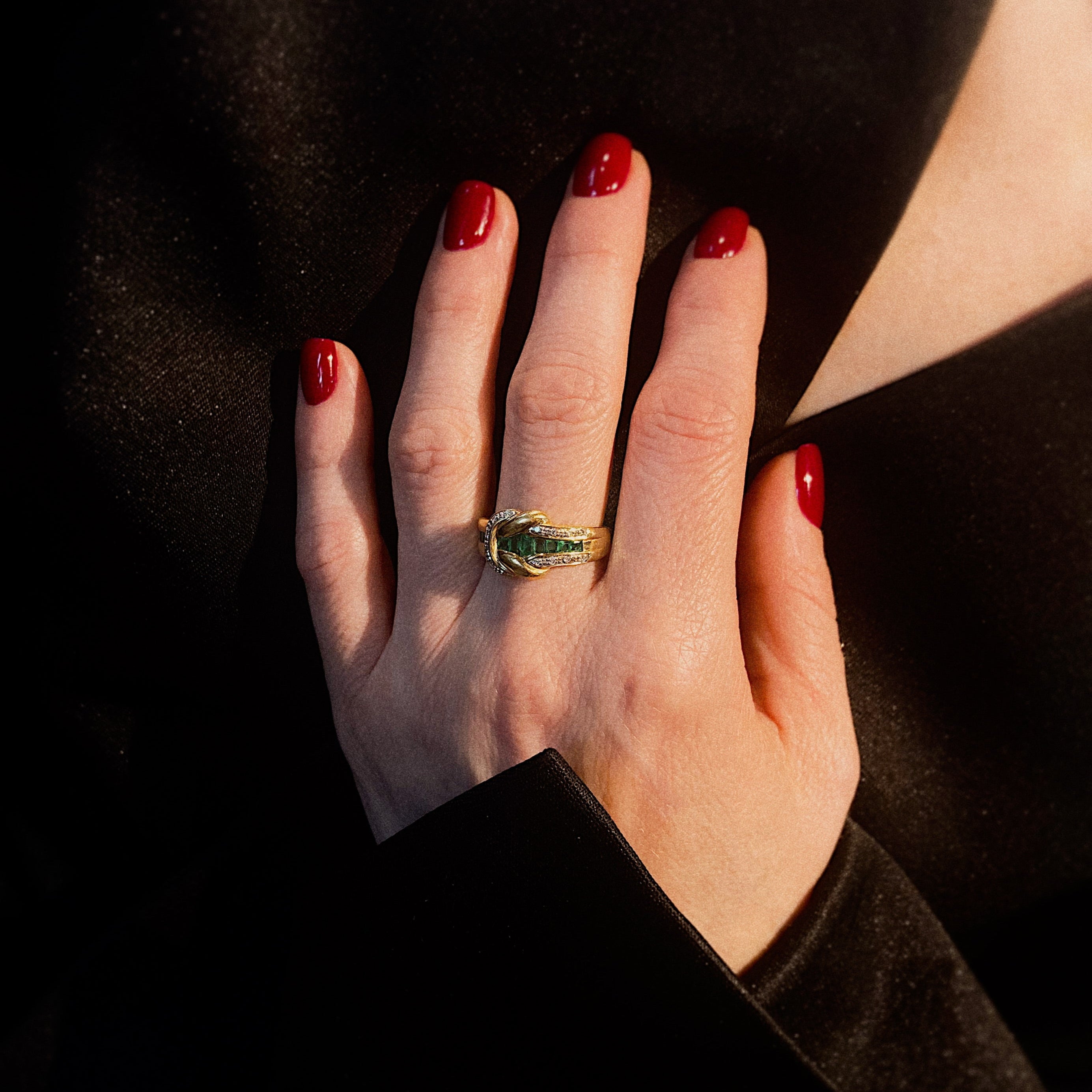 Model wearing the contemporary vintage gold cocktail ring with diamonds and emeralds.
