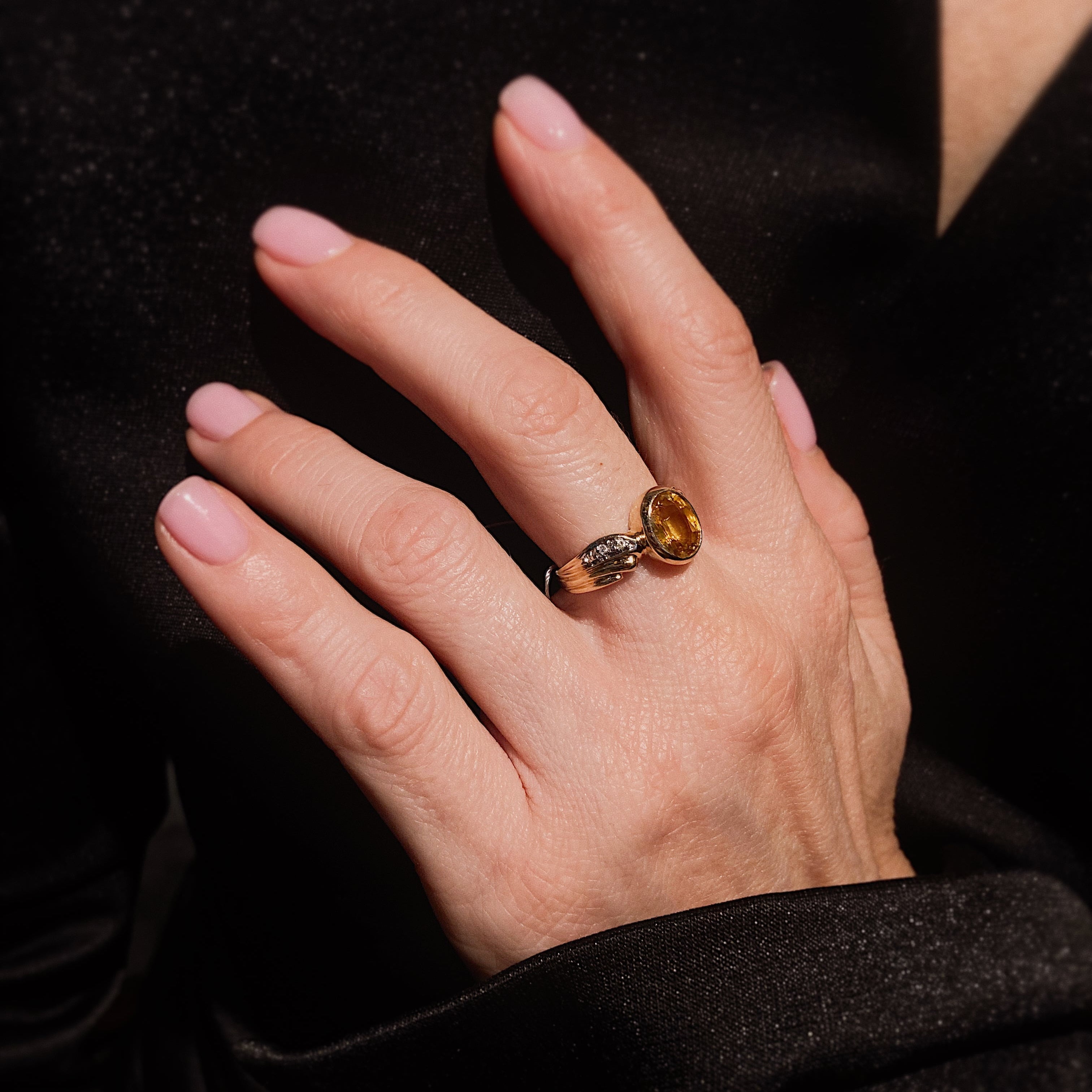 Woman wearing the contemporary vintage yellow gold yellow sapphire and diamond cocktail ring.