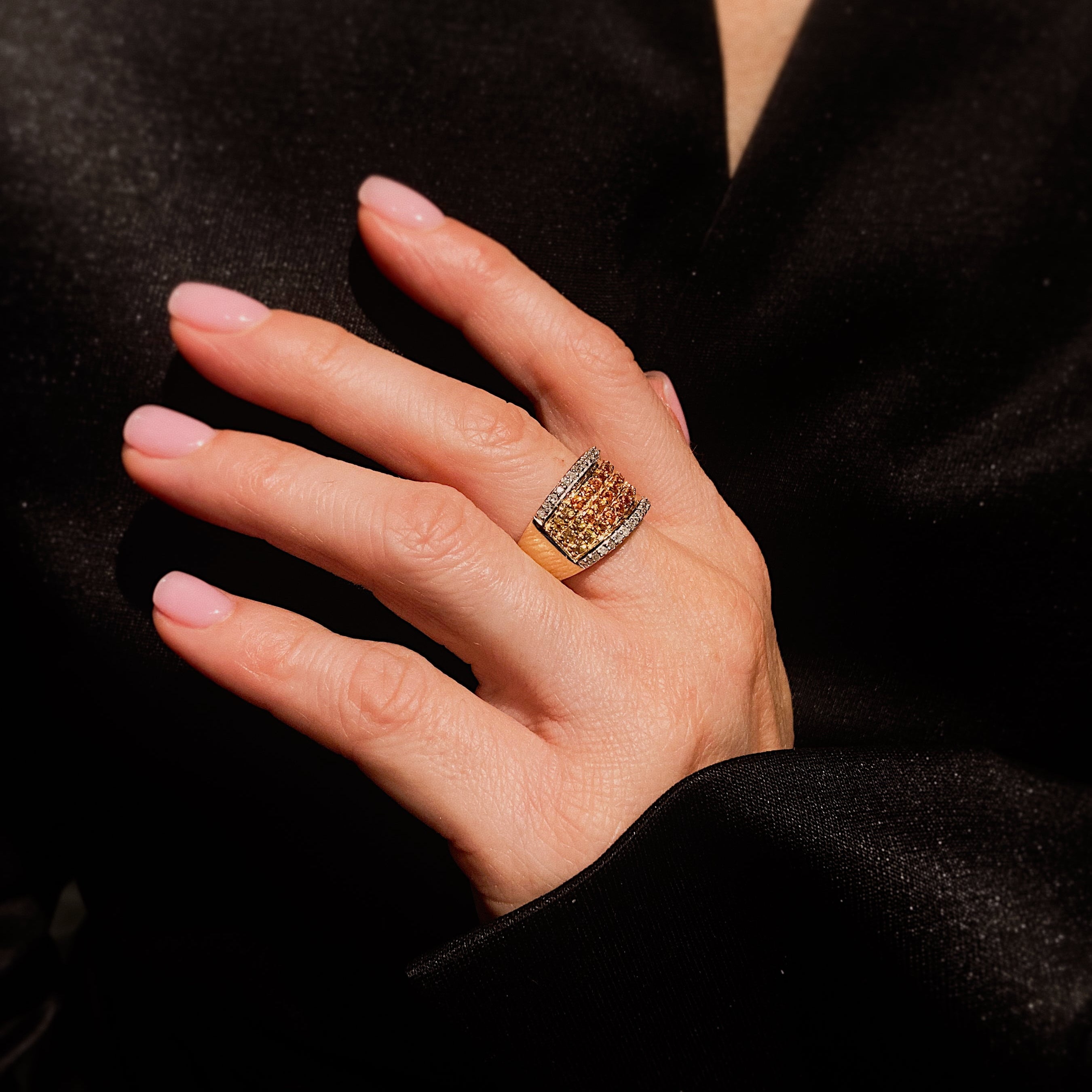 Woman wearing the contemporary vintage gold cocktail ring with ombré yellow sapphires and diamonds.