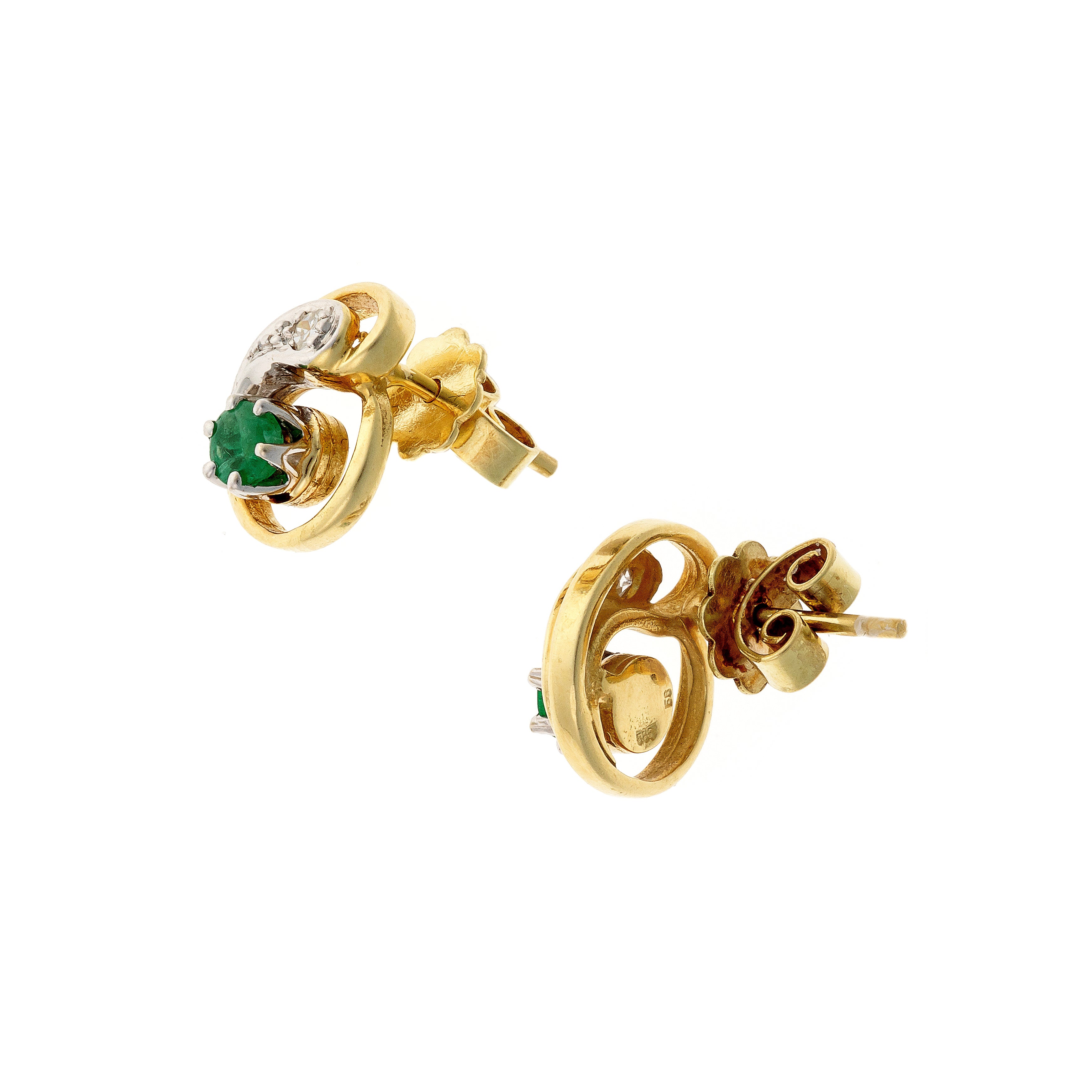 Angled view of the vintage two-tone gold emerald and diamond swirl stud earrings.