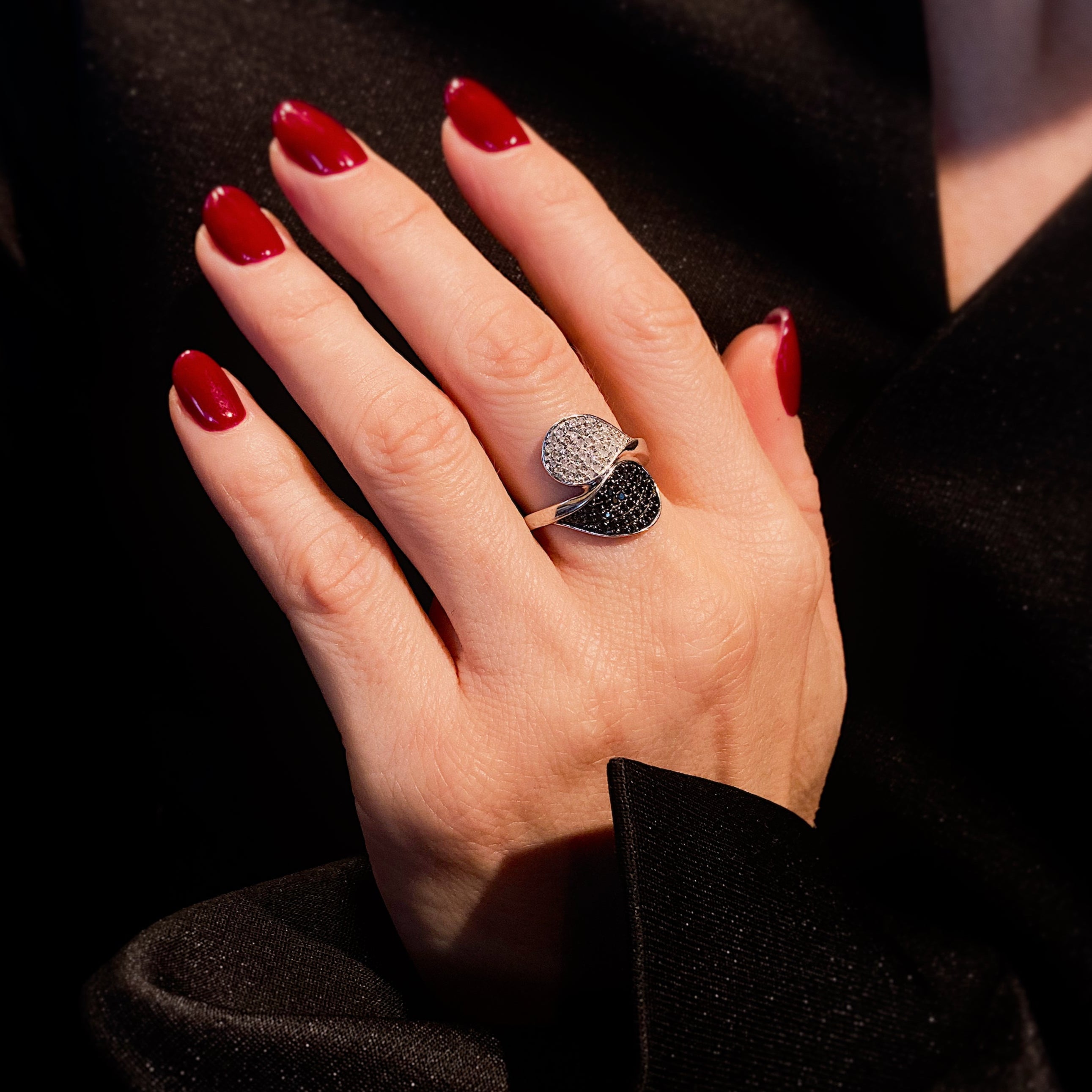 Woman wearing the contemporary vintage white gold ring with black and white diamonds in a yin yang design.