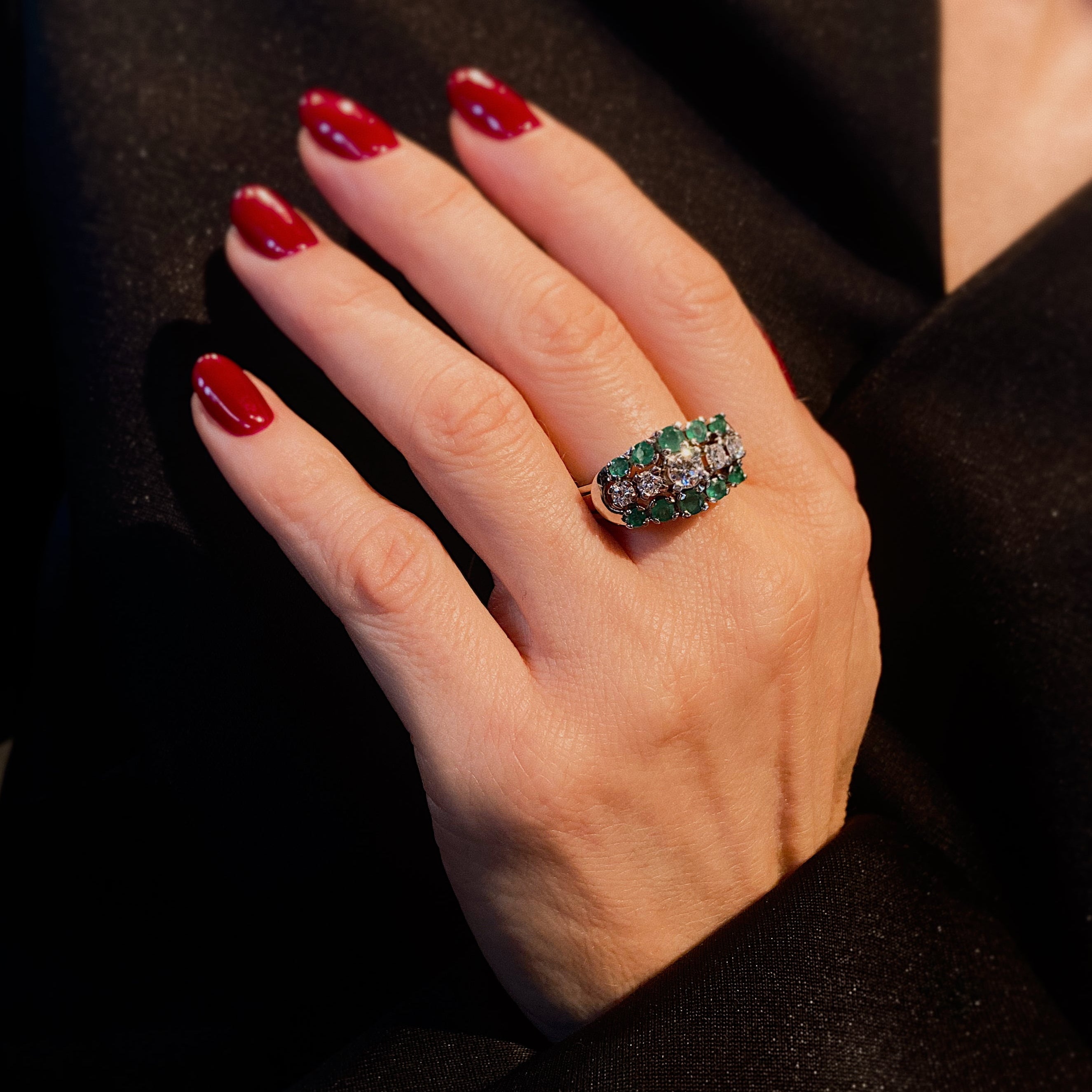 Frau, die den zeitgenössischen Vintage-Weißgold-Smaragd- und Diamant-Cocktailring trägt.