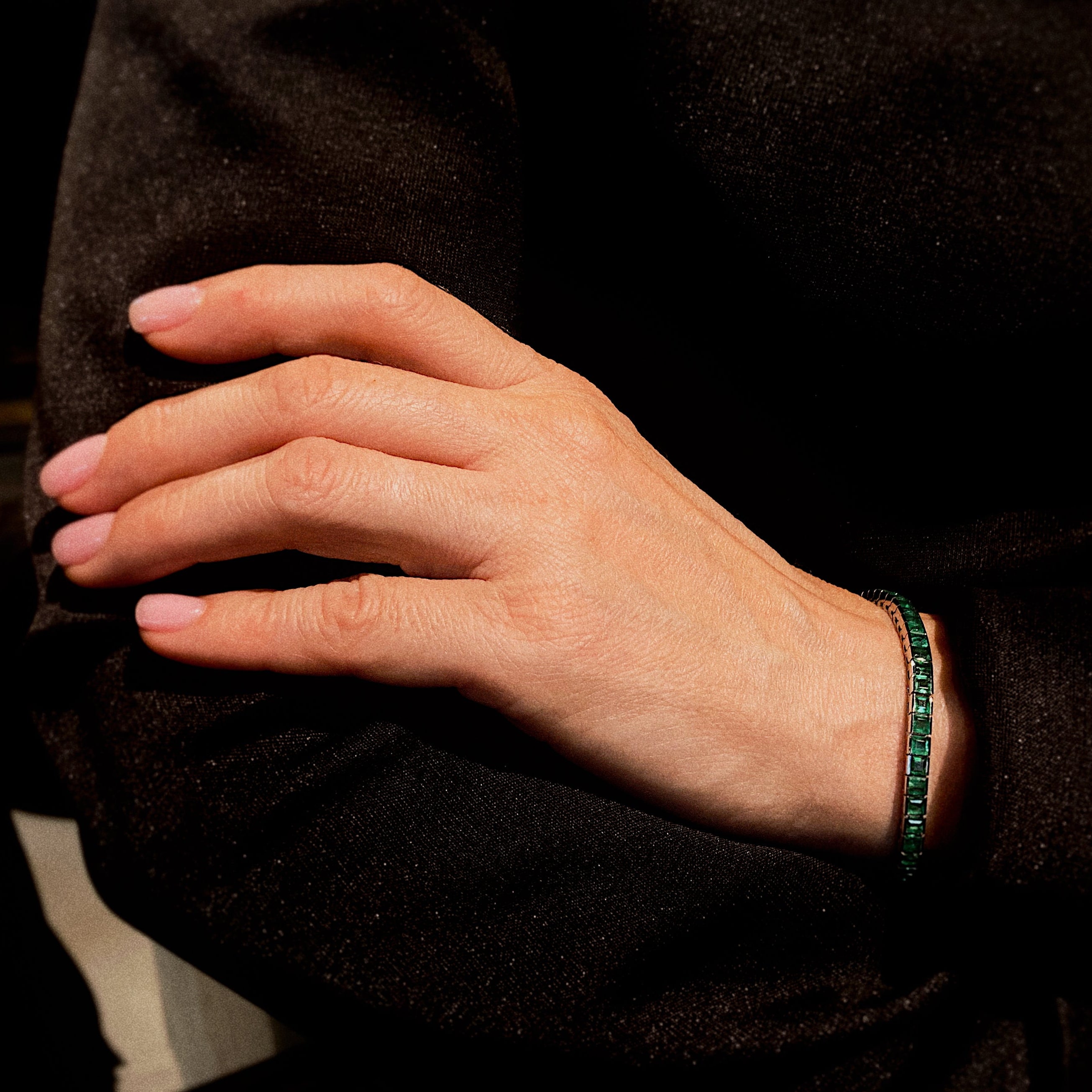 Model wearing the contemporary vintage white gold tennis bracelet with square-cut emeralds.