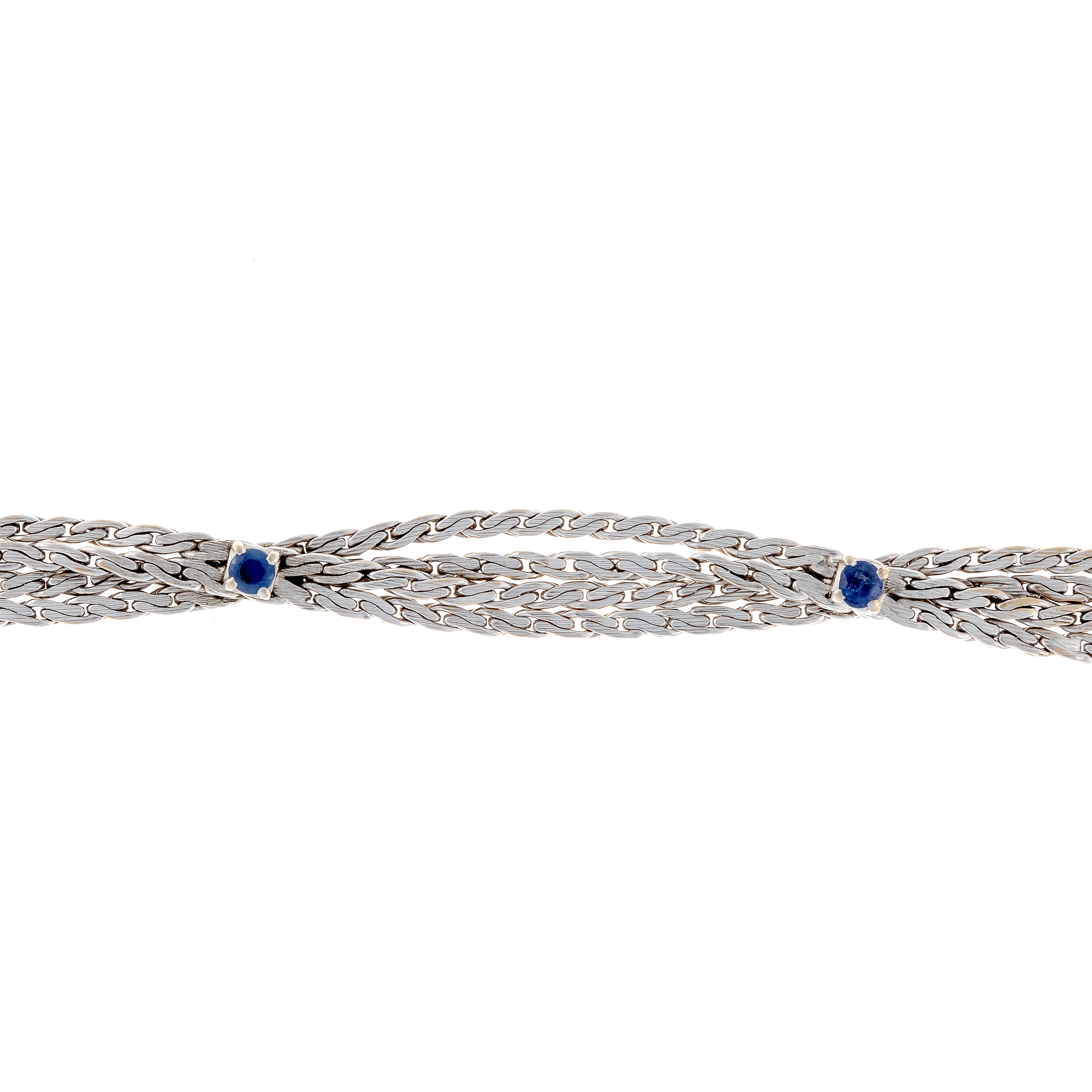 Close-up of the retro revival vintage white gold bracelet with woven design and round sapphires.