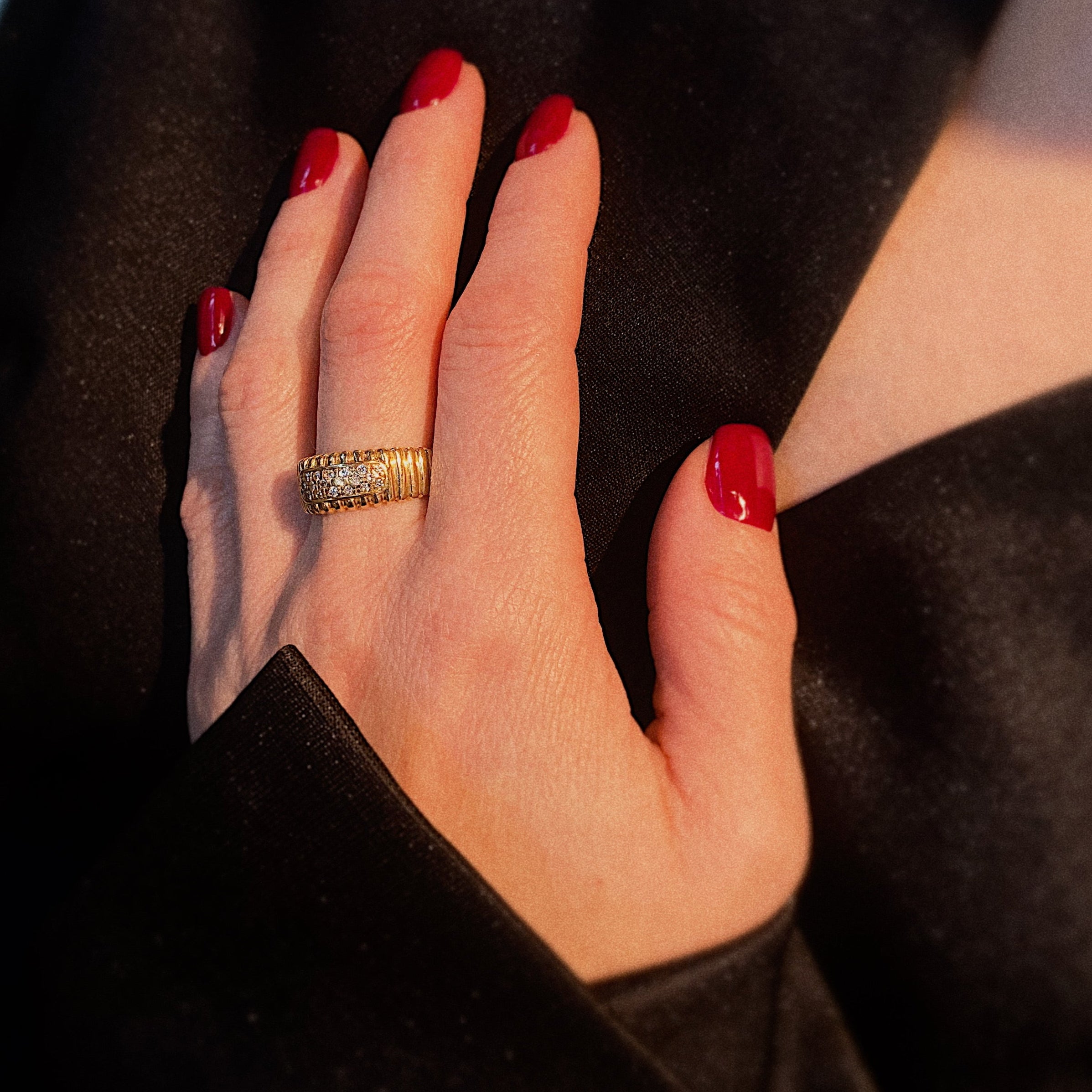 Model wearing the vintage gold ribbed band ring with diamonds.