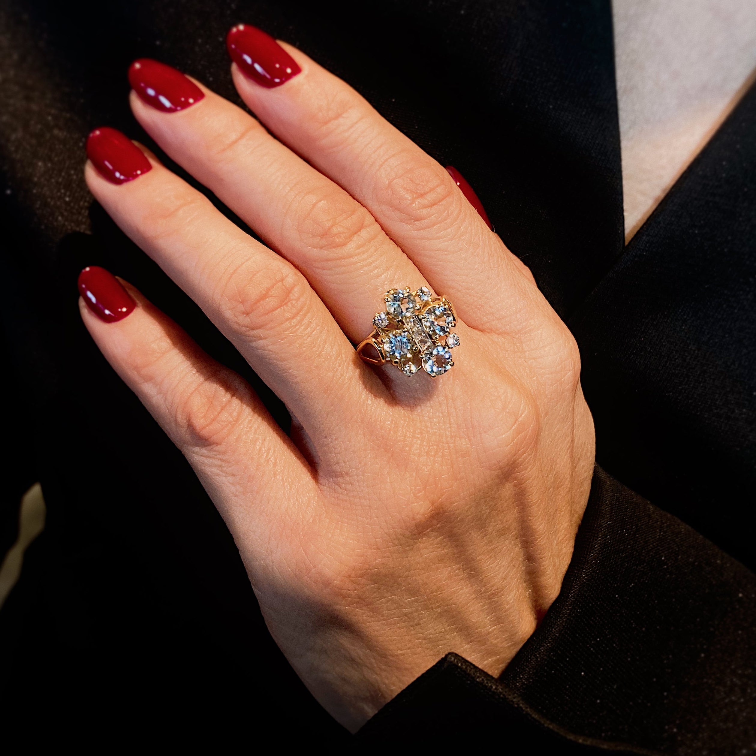 Woman wearing the Early Art Deco yellow gold cocktail ring with aquamarines and diamonds.