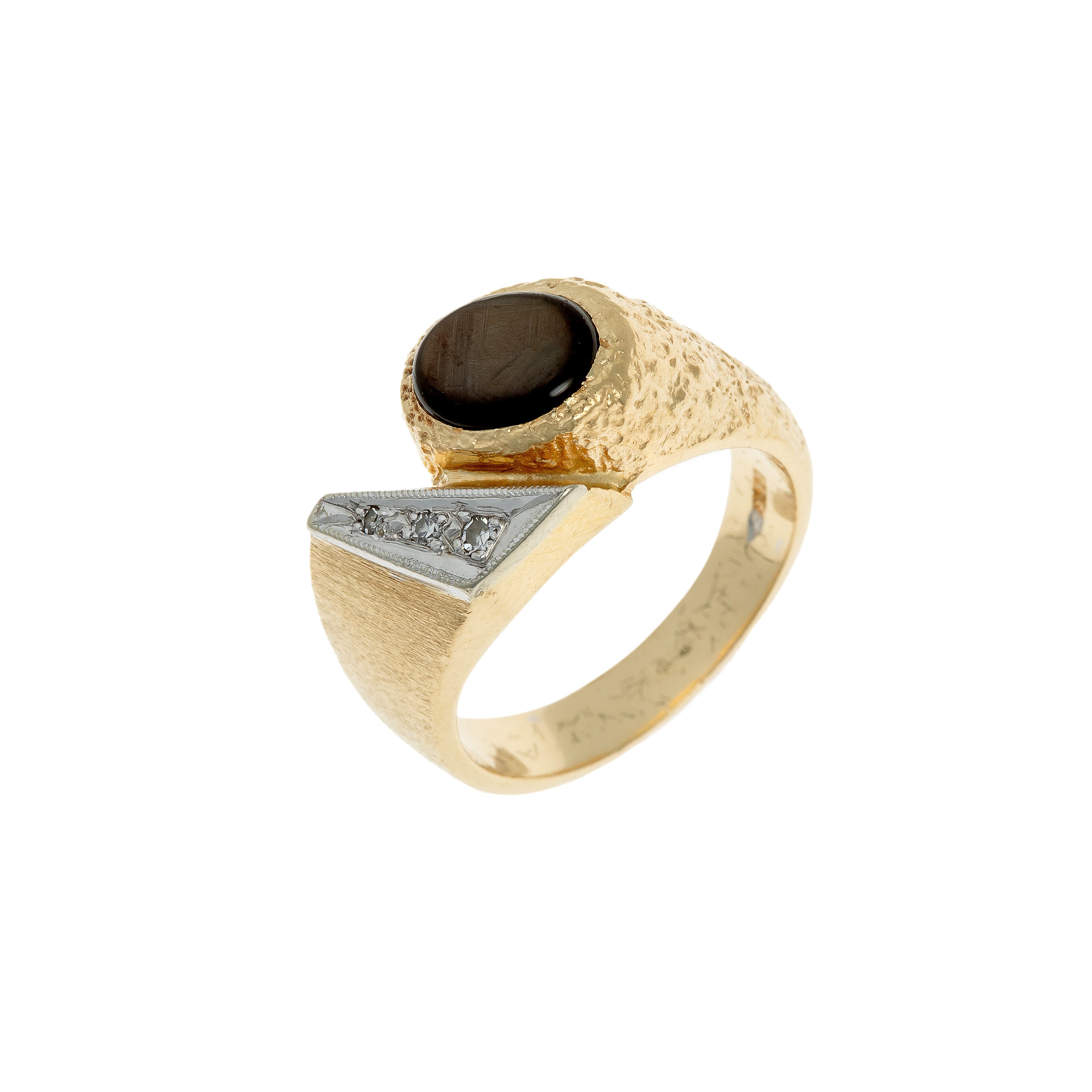 Angled view of a German 1970s avant-garde gold ring featuring a star sapphire and diamonds in a sculptural setting.