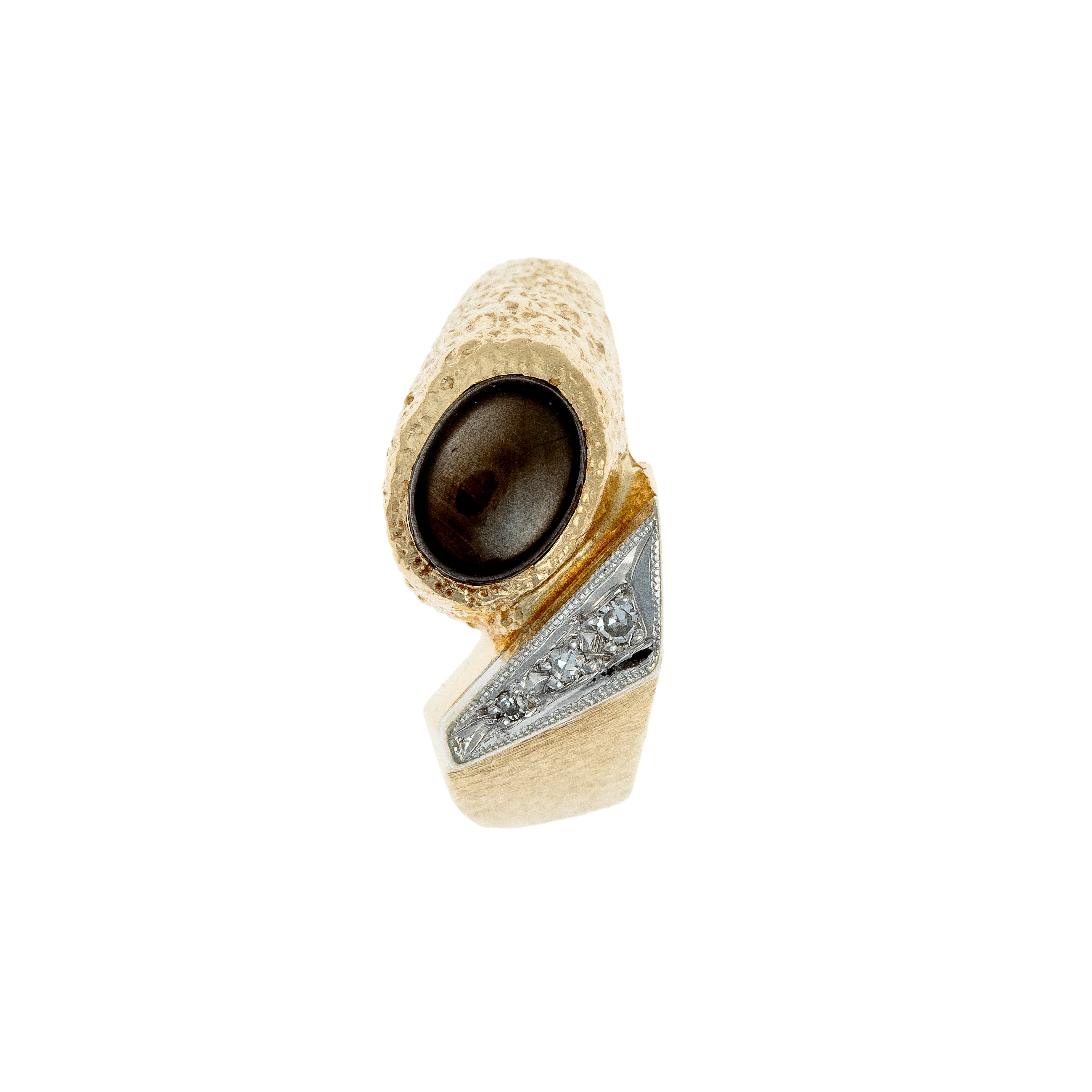 Top-down view of a vintage German gold ring with a star sapphire cabochon and diamond accents.