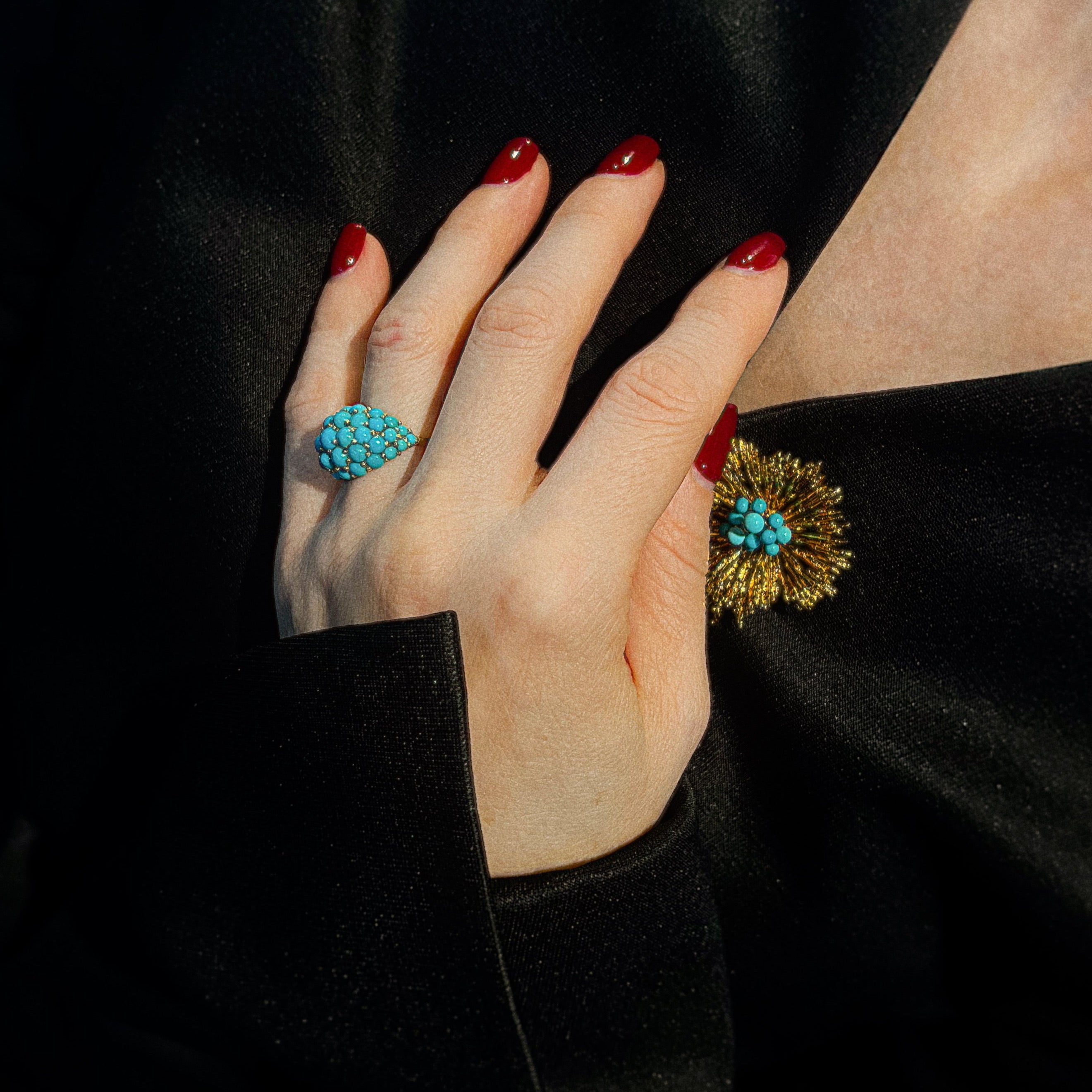 Model wearing the mid-century gold cocktail dome ring with turquoise colored beads.
