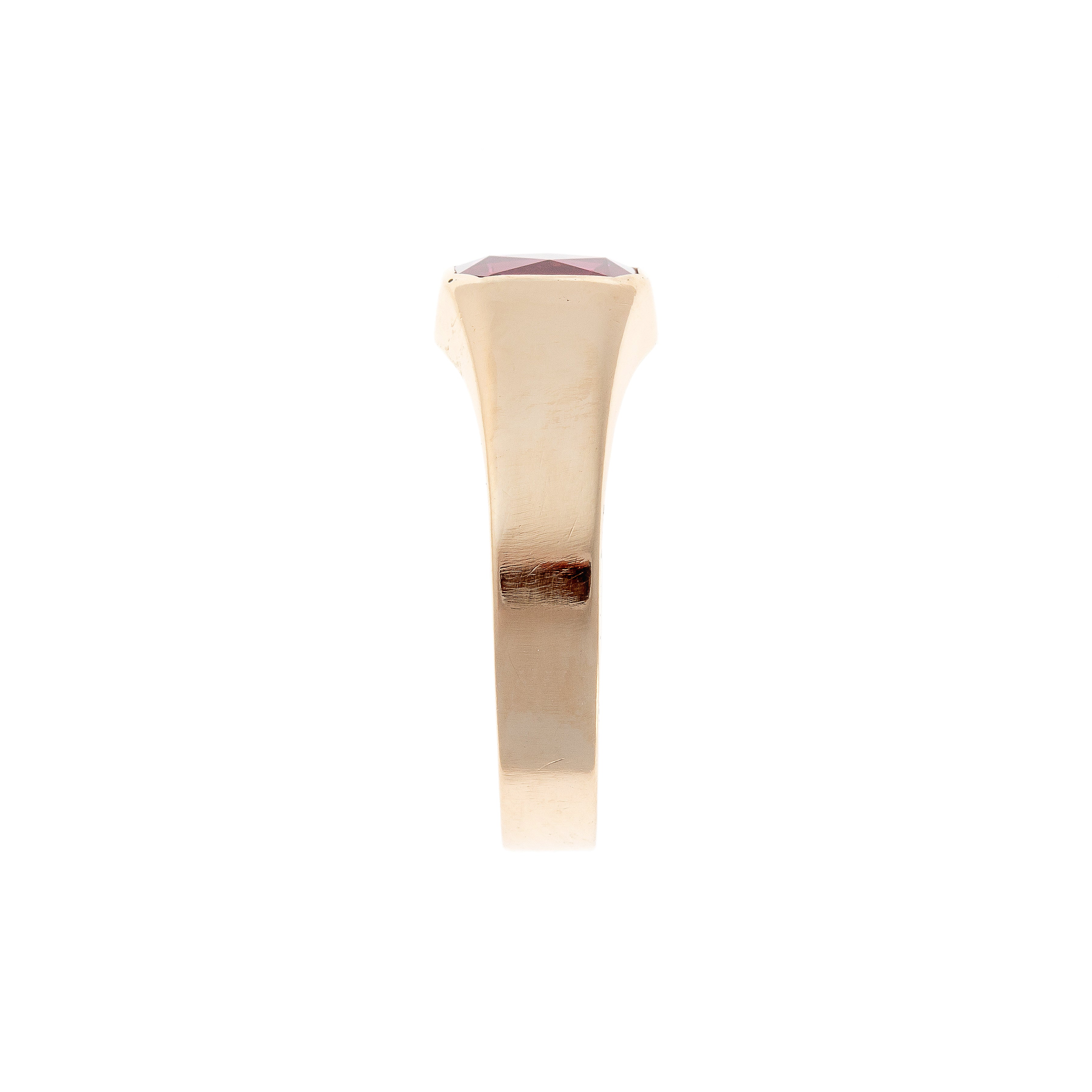 Profile view of a vintage 14K gold signet ring, highlighting its bold, sculptural contours and deep red lab-grown ruby.