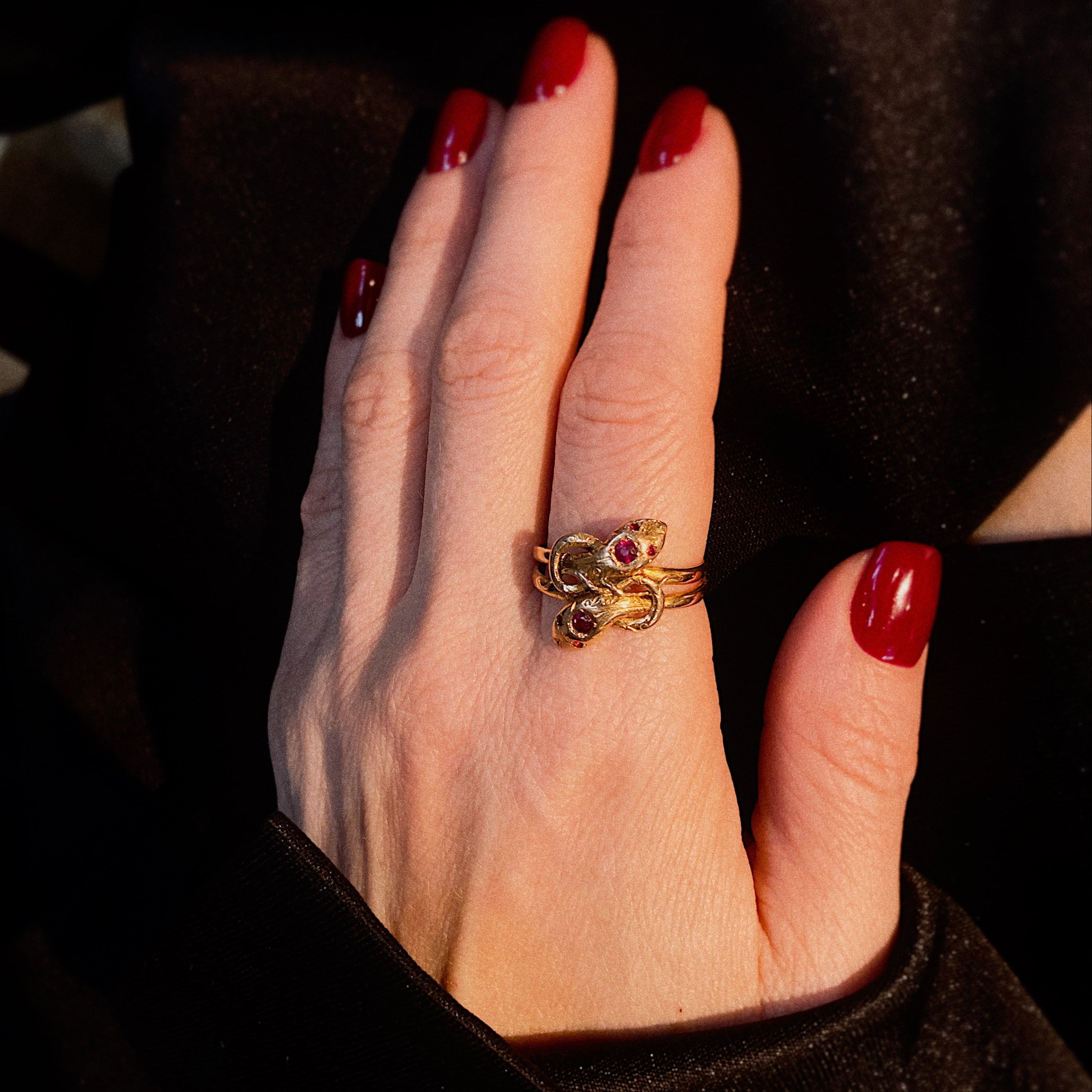 Model wearing the mid-century gold snake ring with ruby heads.