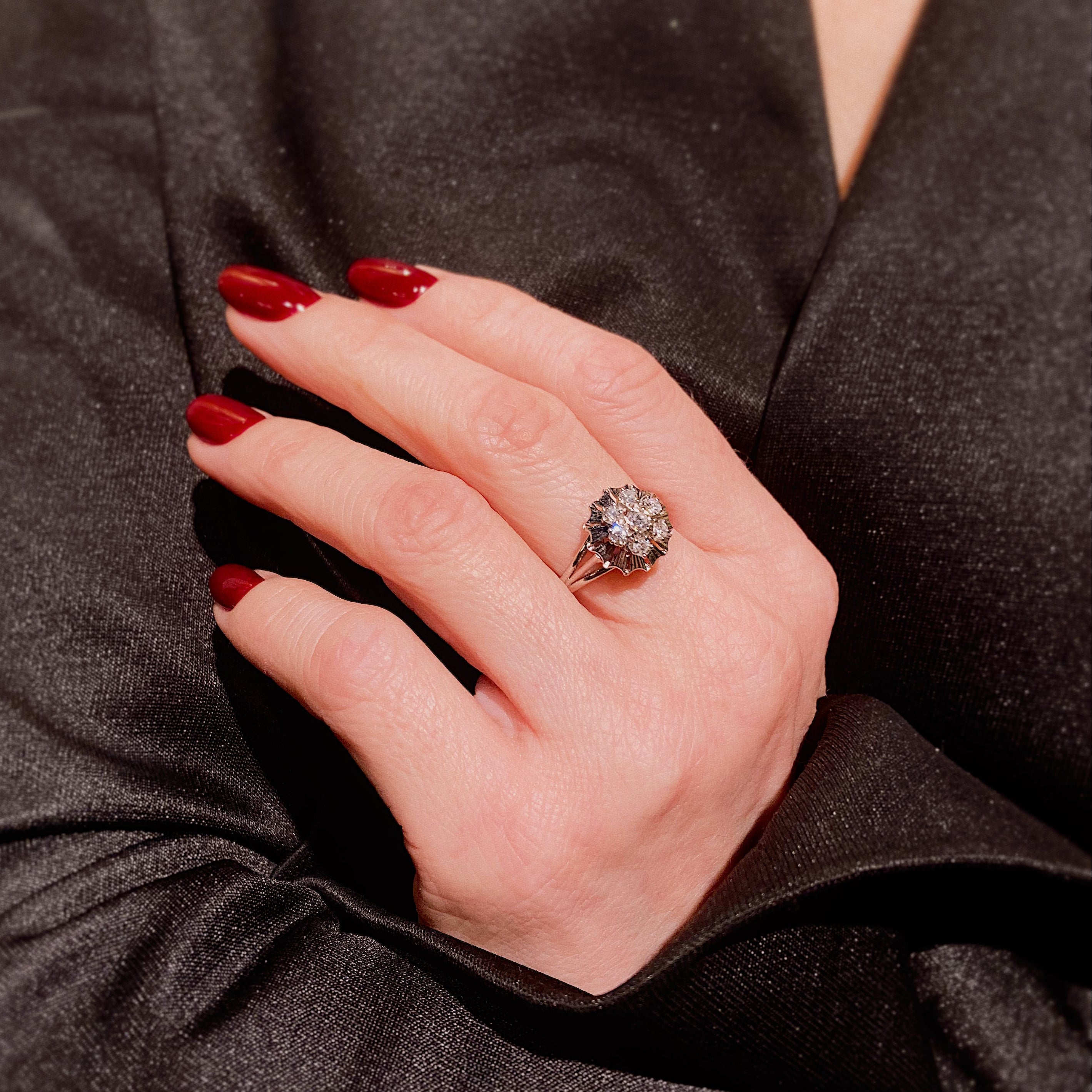 Woman's hand wearing the Mid-Century white gold diamond ballerina cluster ring.