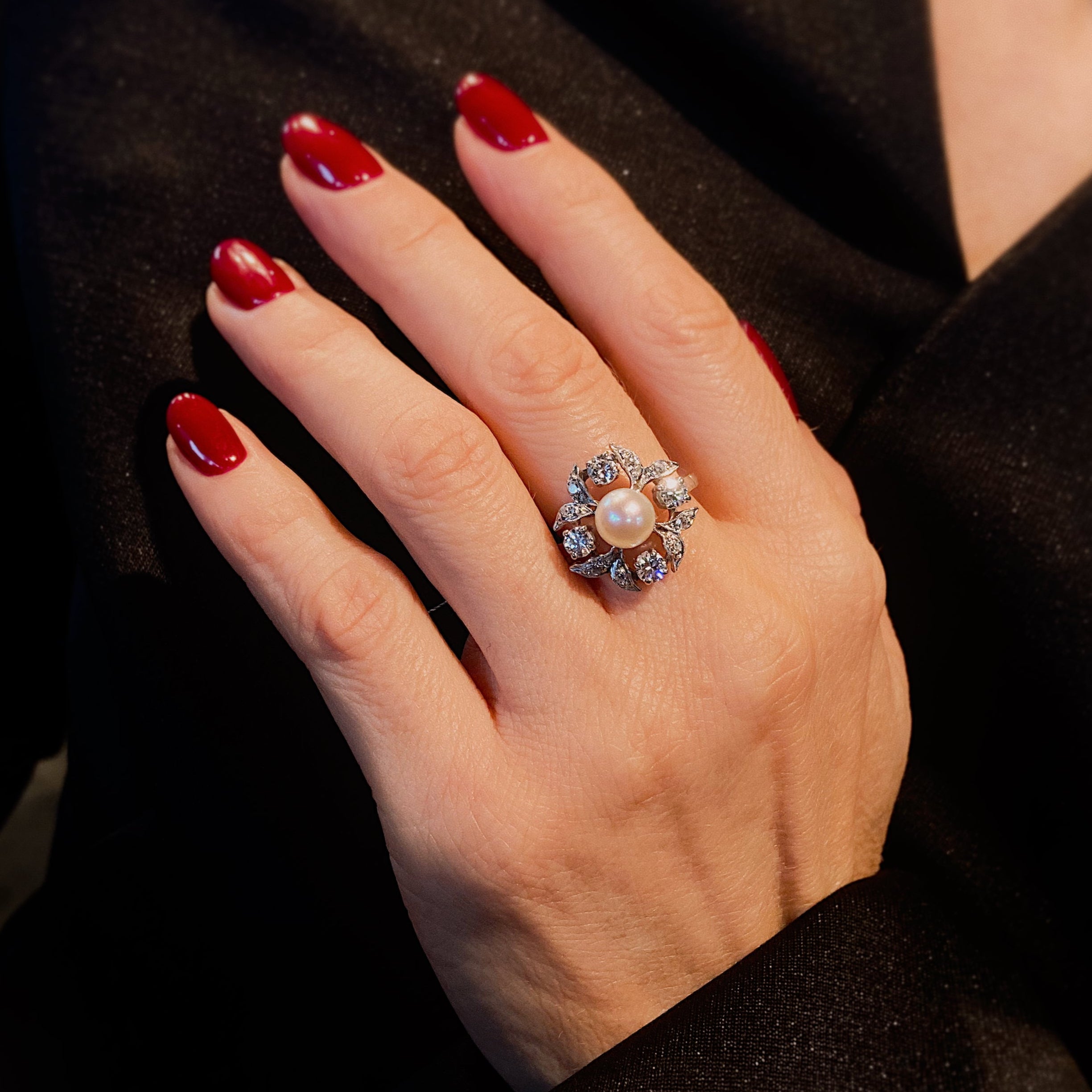 Woman model wearing the vintage mid-century white gold floral ring with pearl and diamonds.