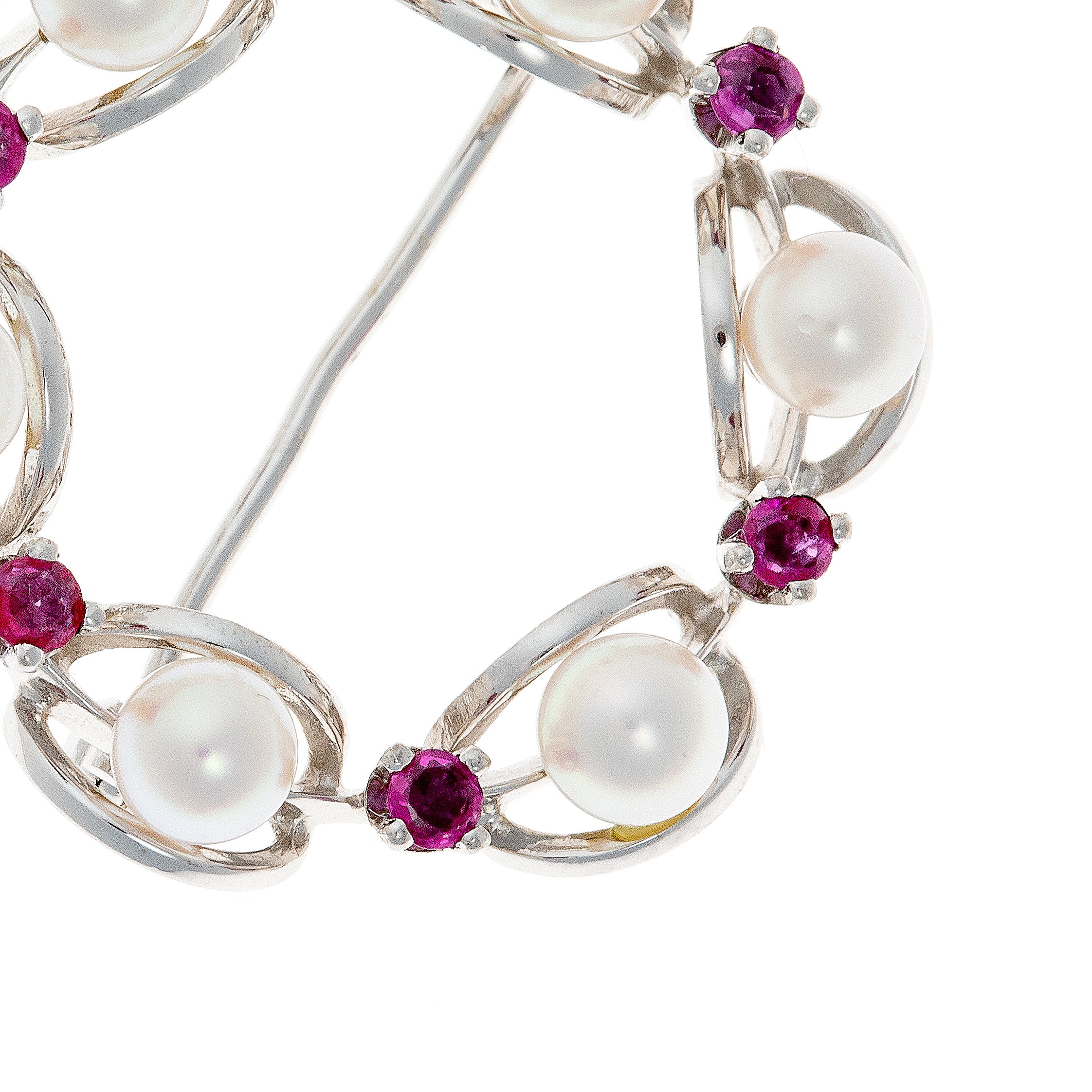 Close-up of cultured pearls and rubies in a Mid-Century white gold wreath brooch, highlighting gemstone brilliance and design details.