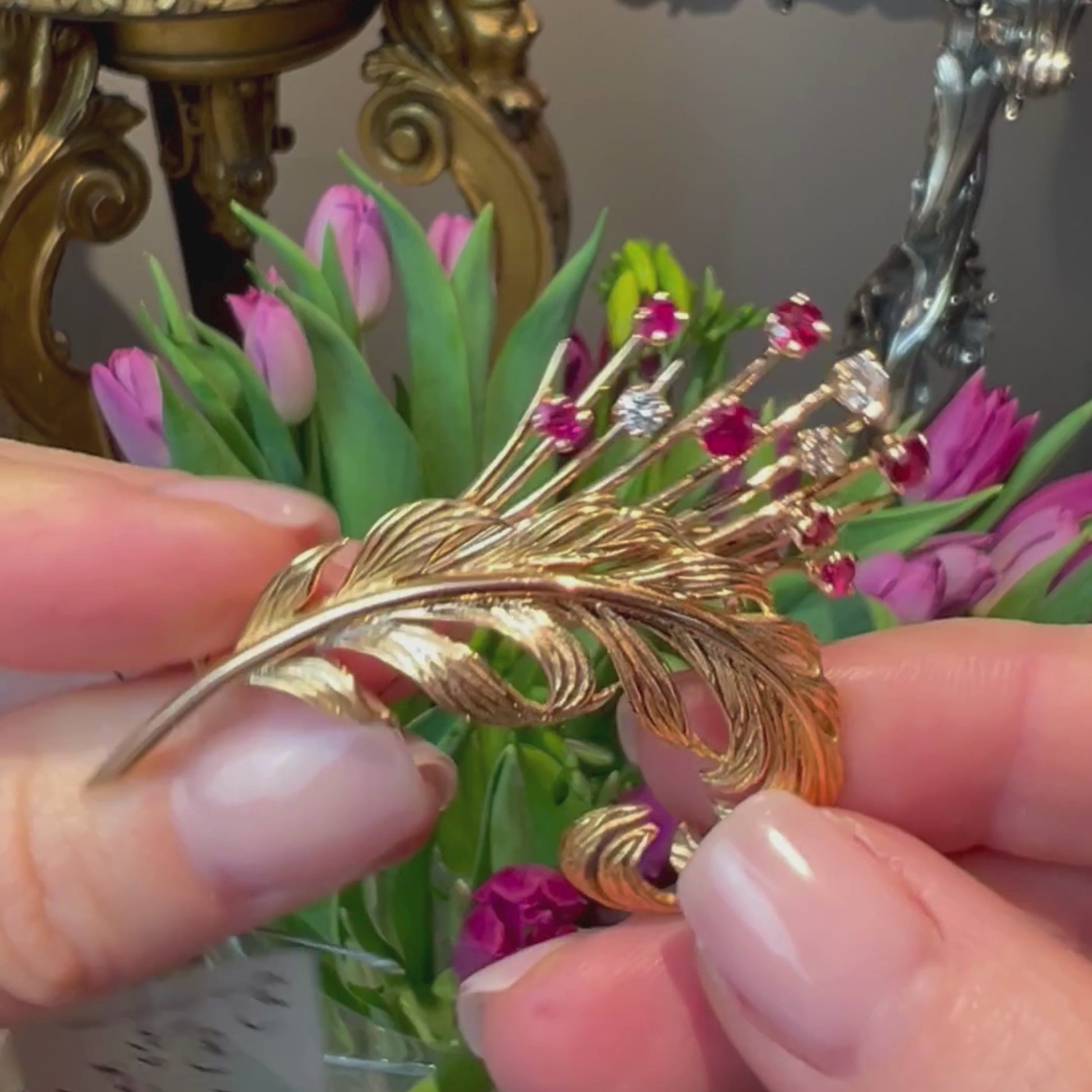 Video of model holding the vintage gold feather brooch with diamonds and rubies.