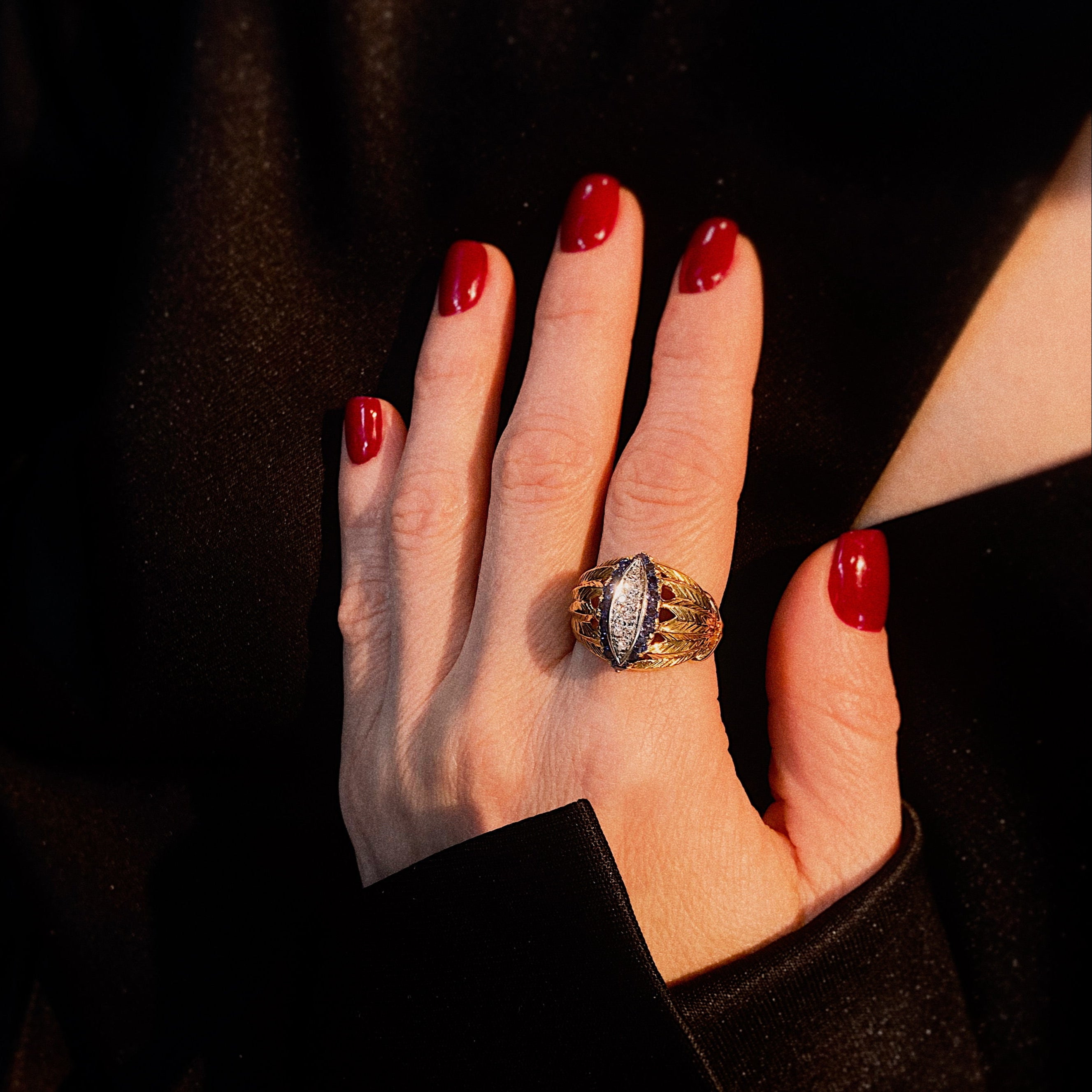 Model wearing the retro gold marquise cocktail ring with diamonds and sapphires.
