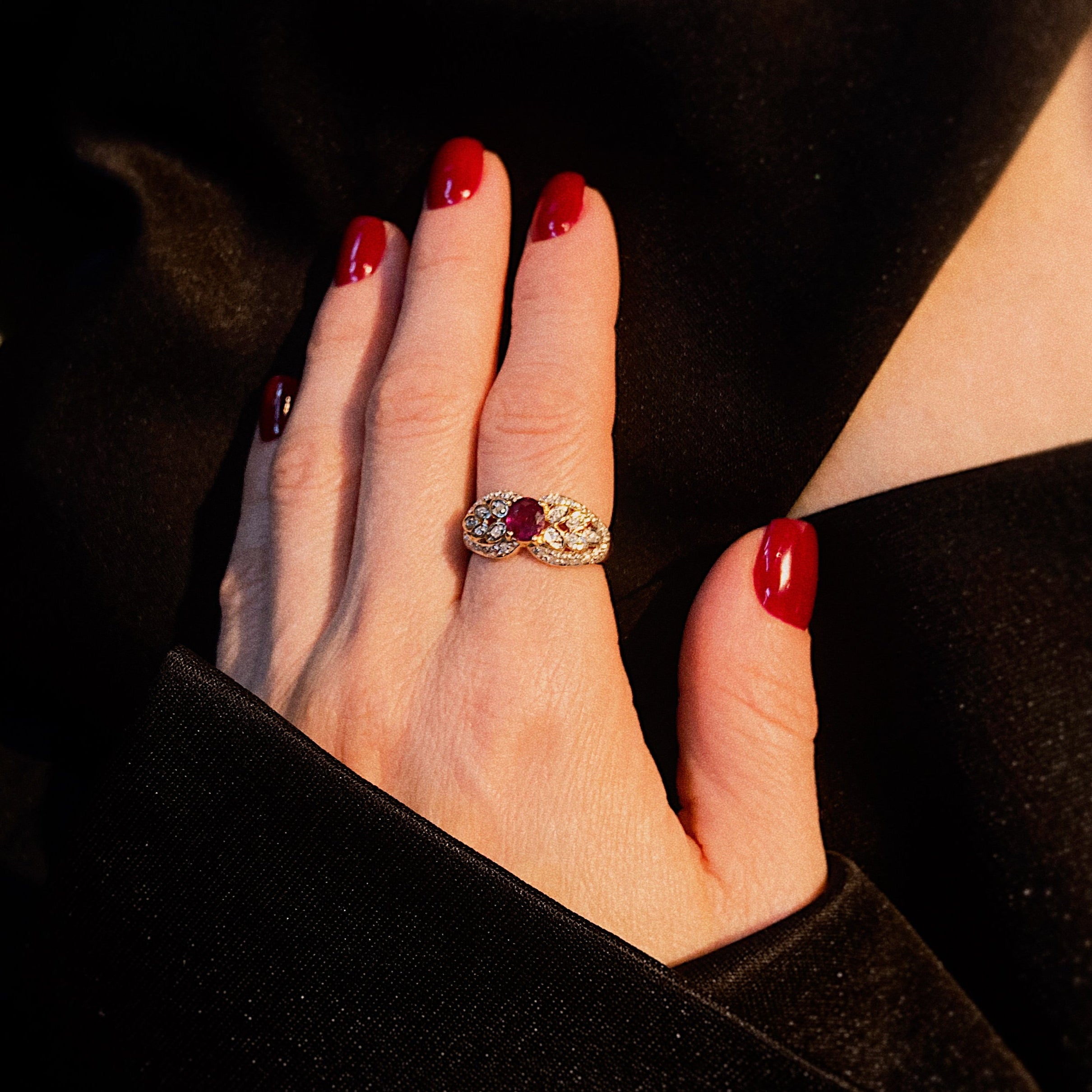Model wearing the vintage gold cocktail ring with ruby and diamond floral cluster.
