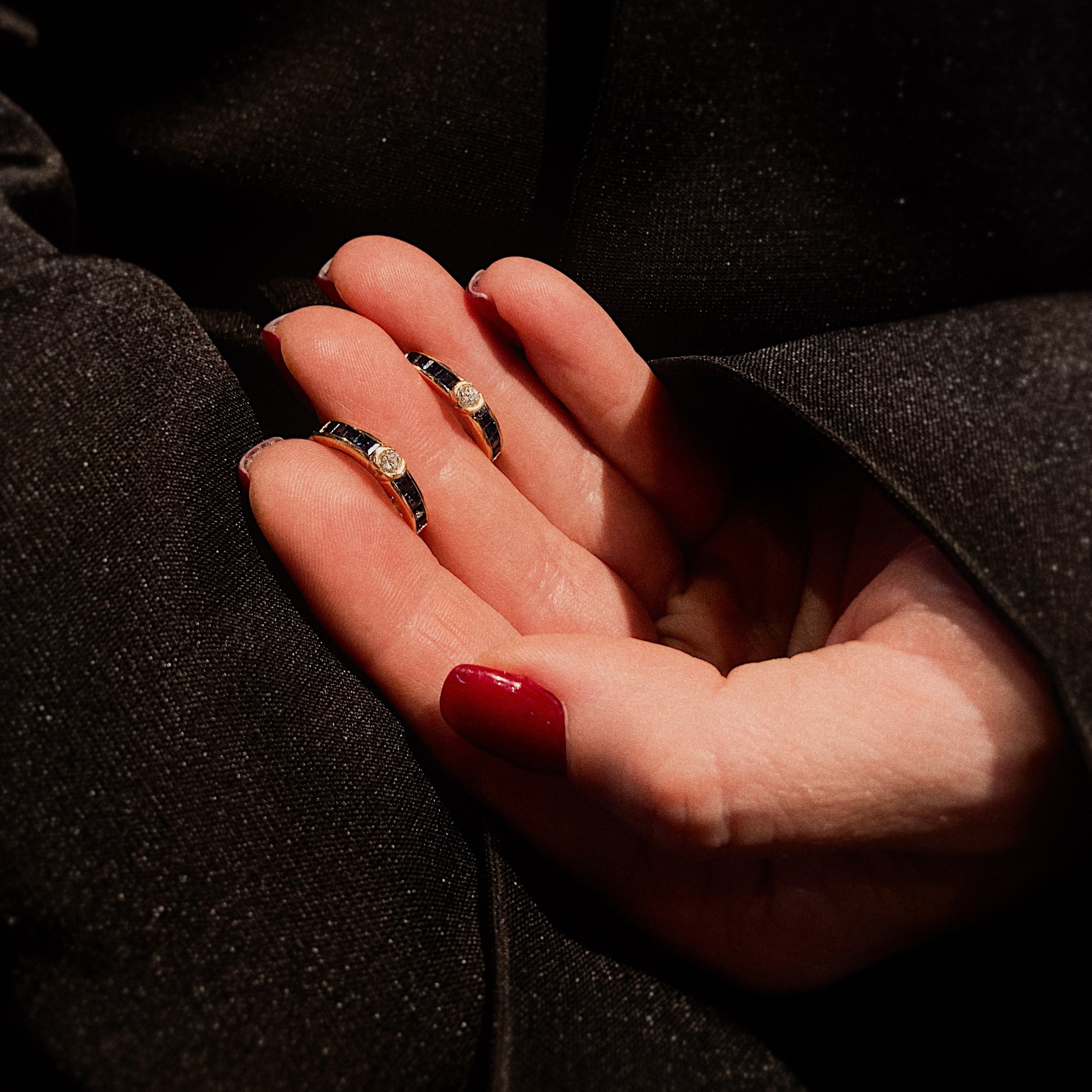 Model holding the vintage gold sapphire and diamond hoop earrings.