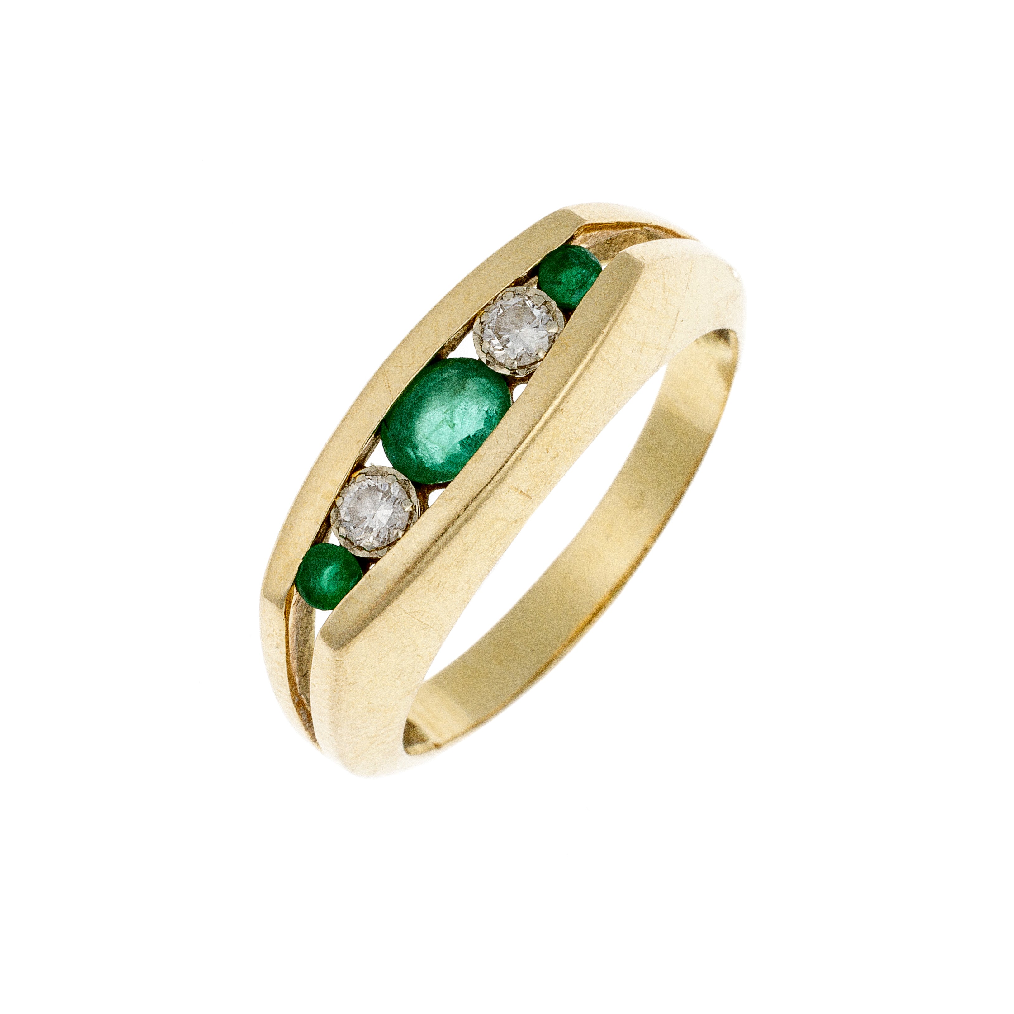 Angled shot of sleek gold band with row-set emeralds and diamonds in polished channel setting.