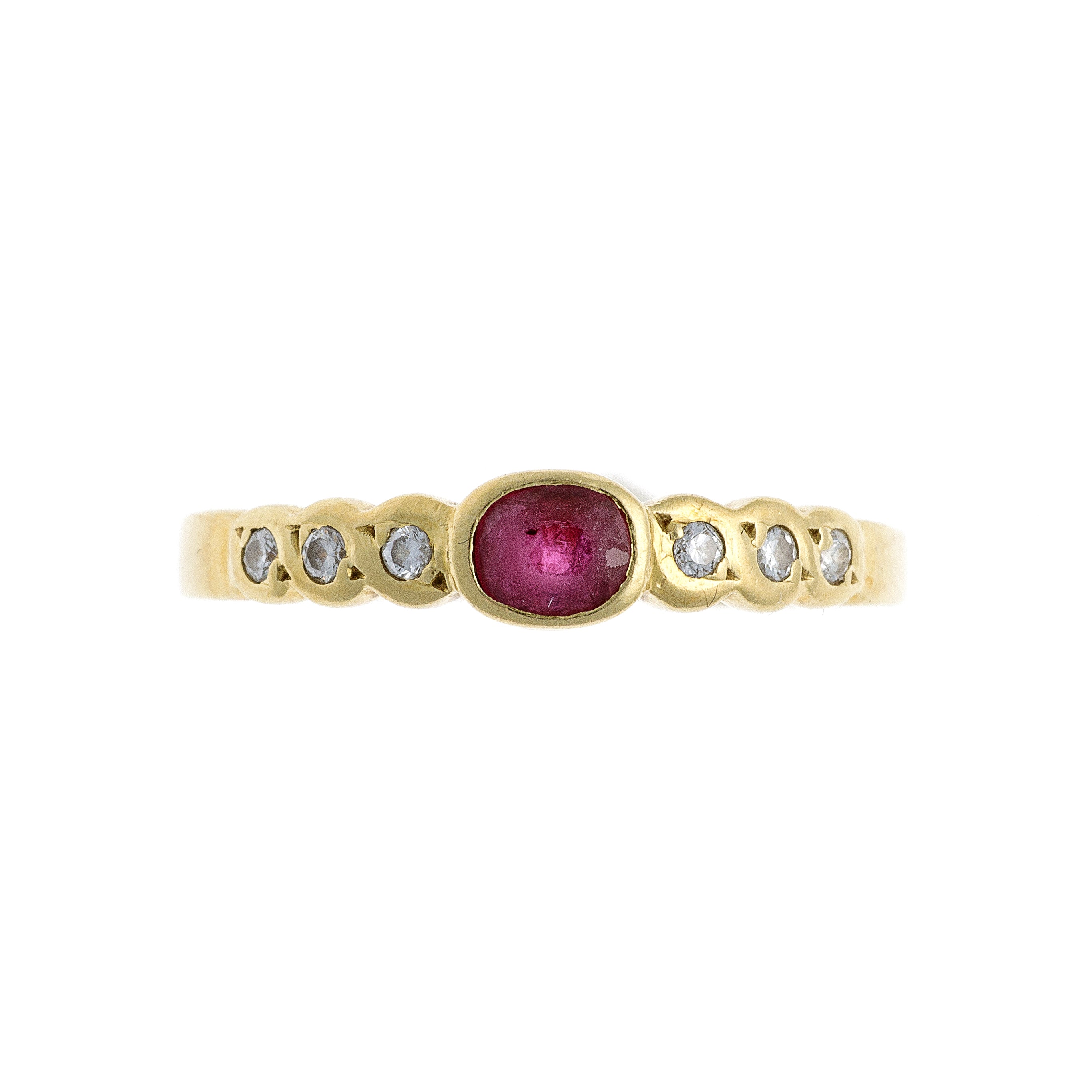 A vintage 18K gold band ring featuring an oval ruby center flanked by six brilliant-cut diamonds in an elegant setting.