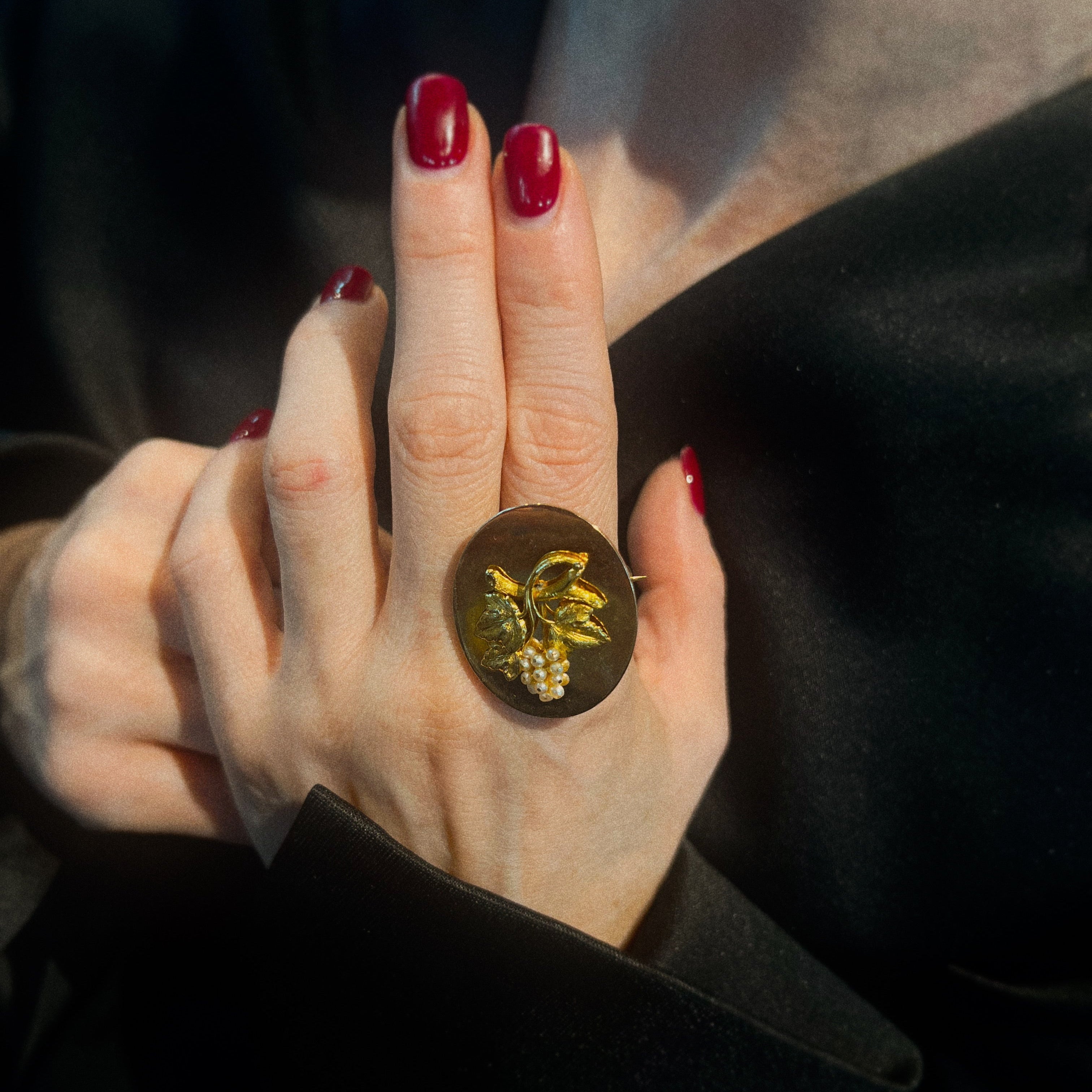 Model wearing the vintage gold brooch with grapevine motive in pearl cluster.