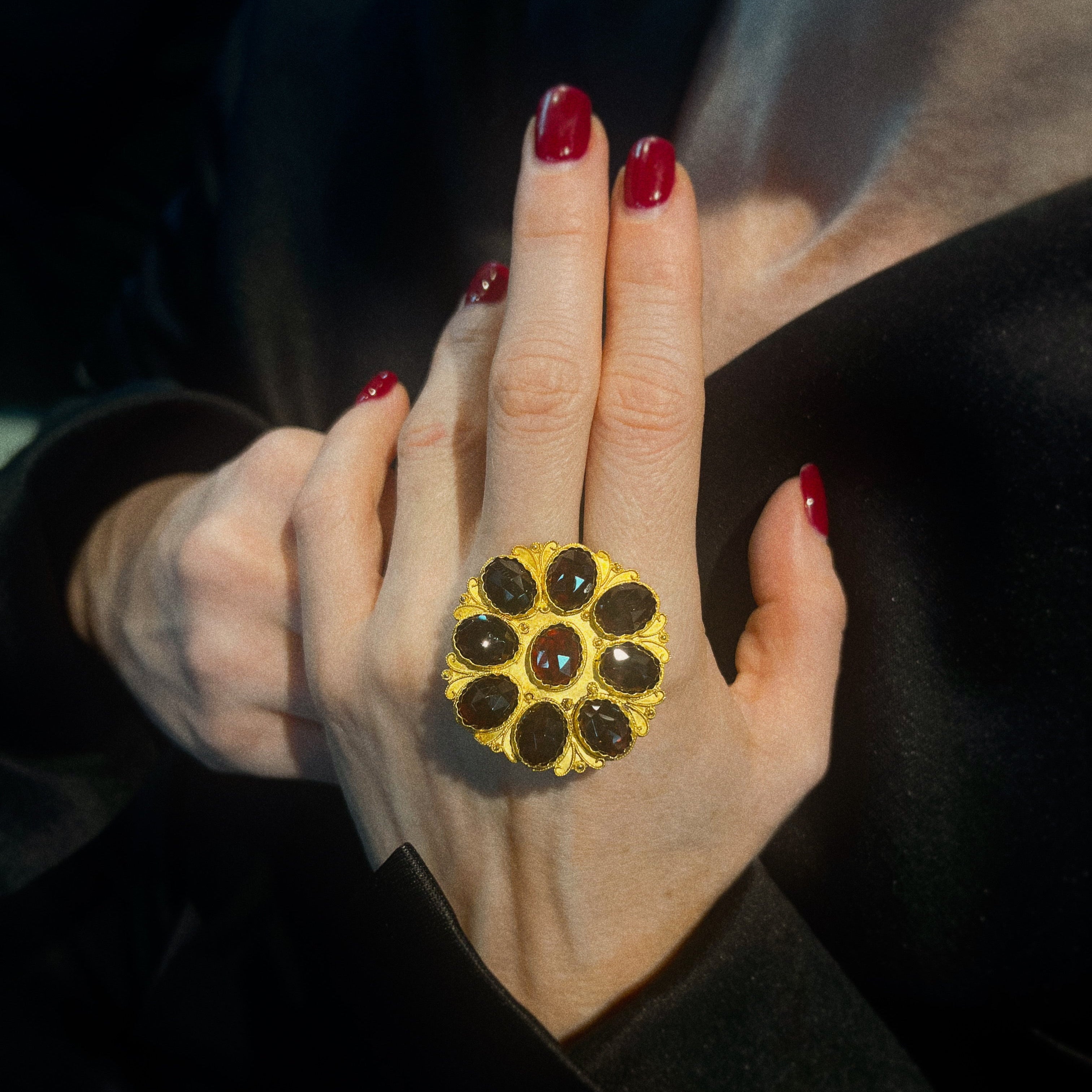 Model holding the vintage gold brooch with garnets.