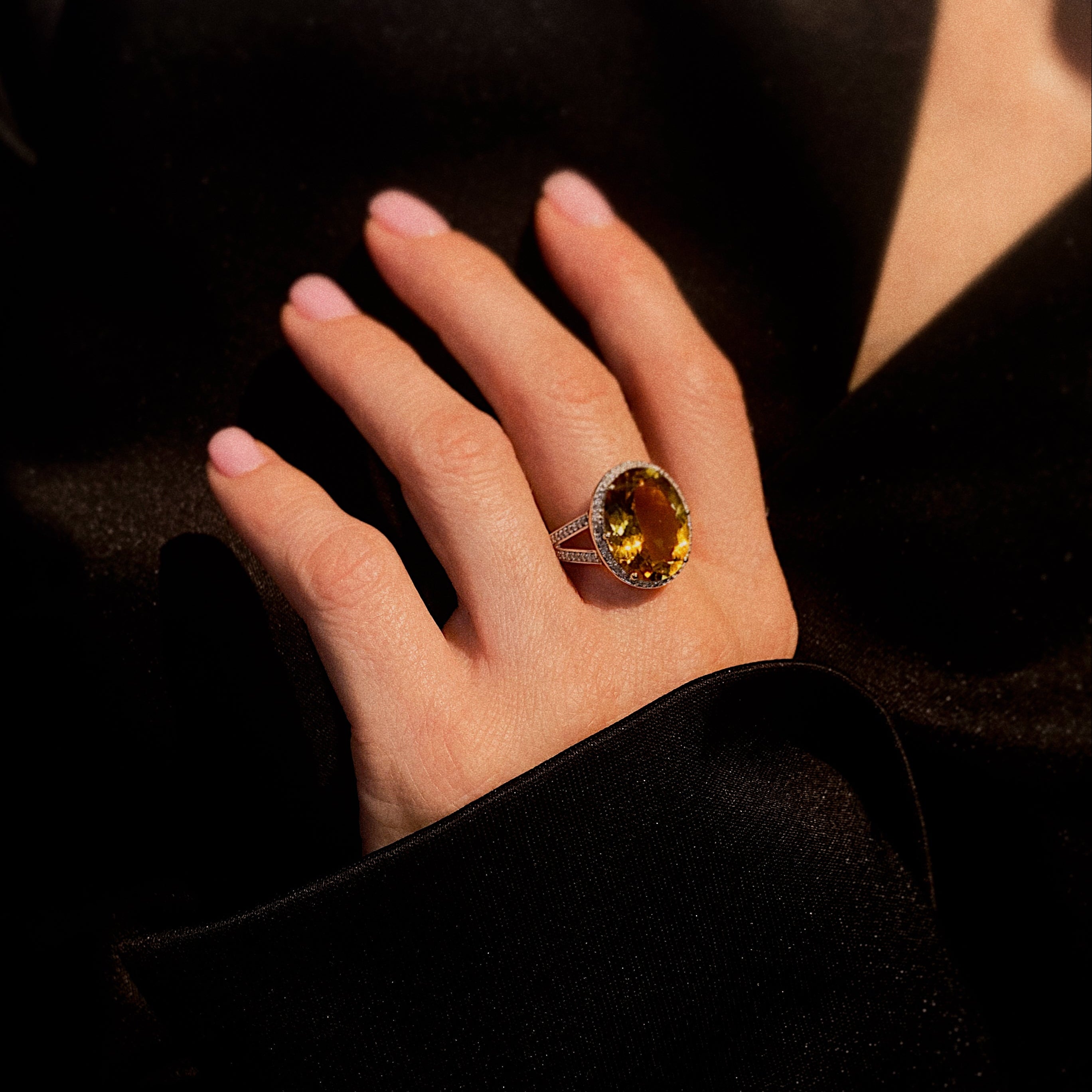 Model hand wearing the contemporary vintage gold cocktail ring with faceted heliodor and diamond halo.