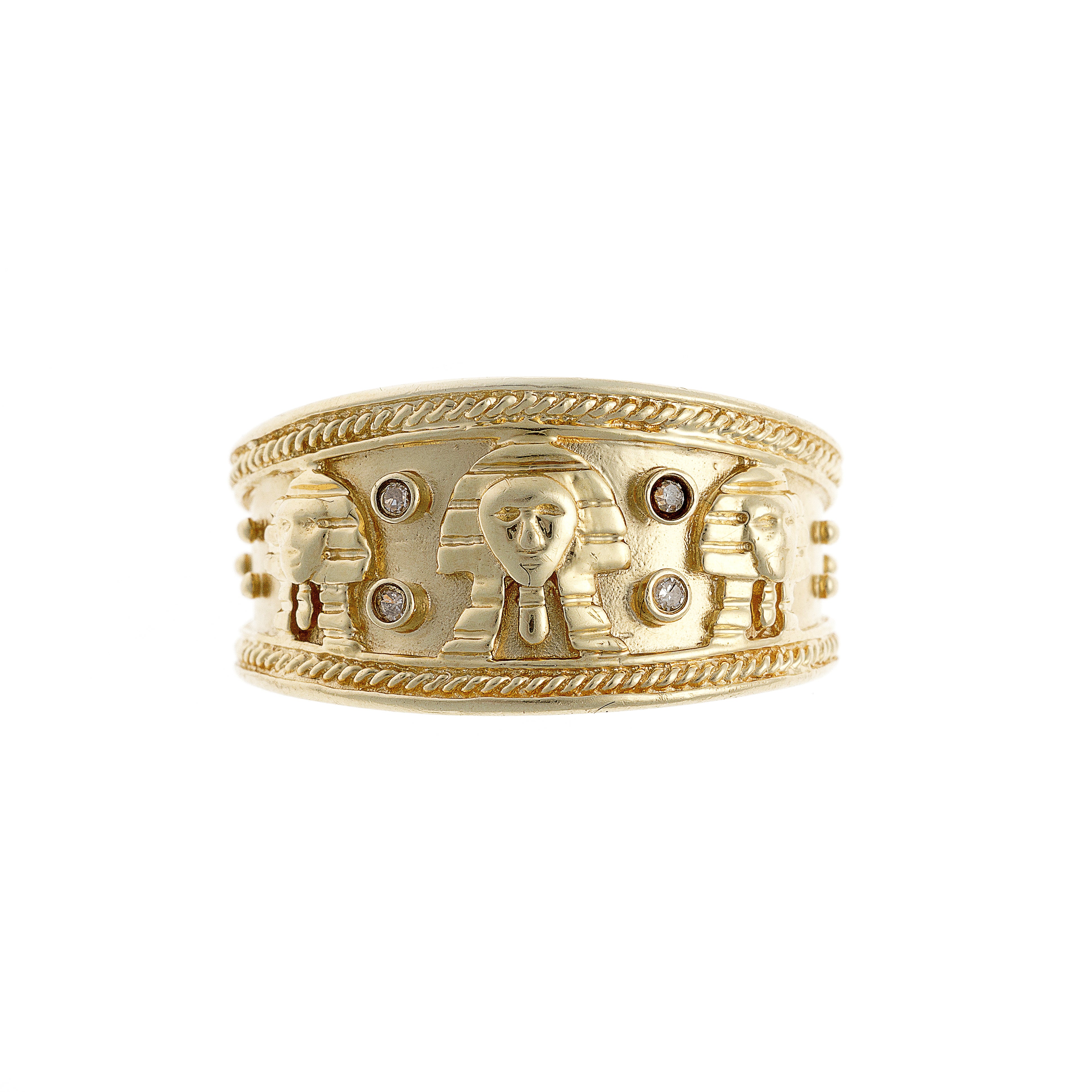 Une large bague jonc vintage en or 14K ornée de têtes de pharaon sculptées, de bords tressés et d'accents de diamant.