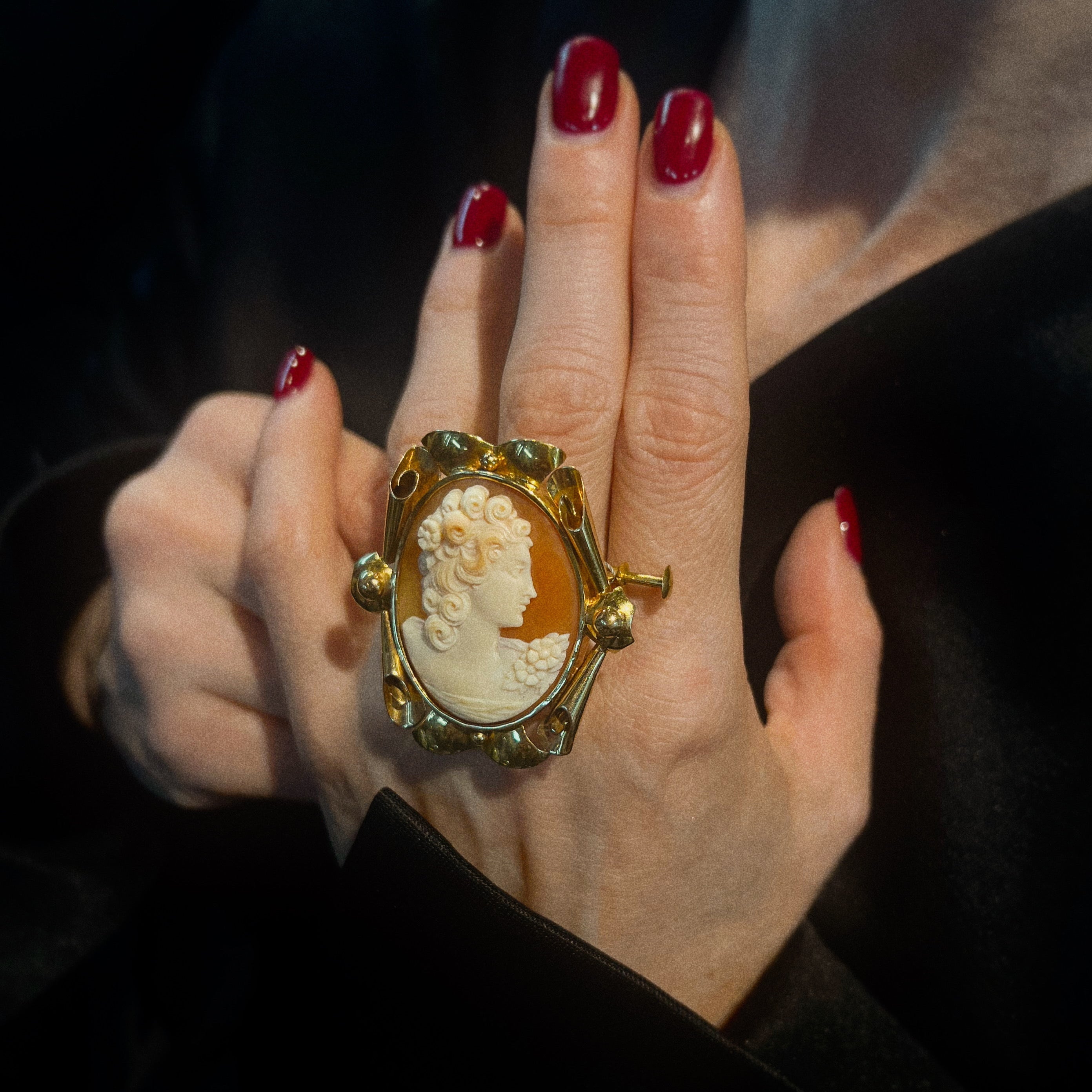 Model holding the vintage mid-century gold brooch with shell cameo.