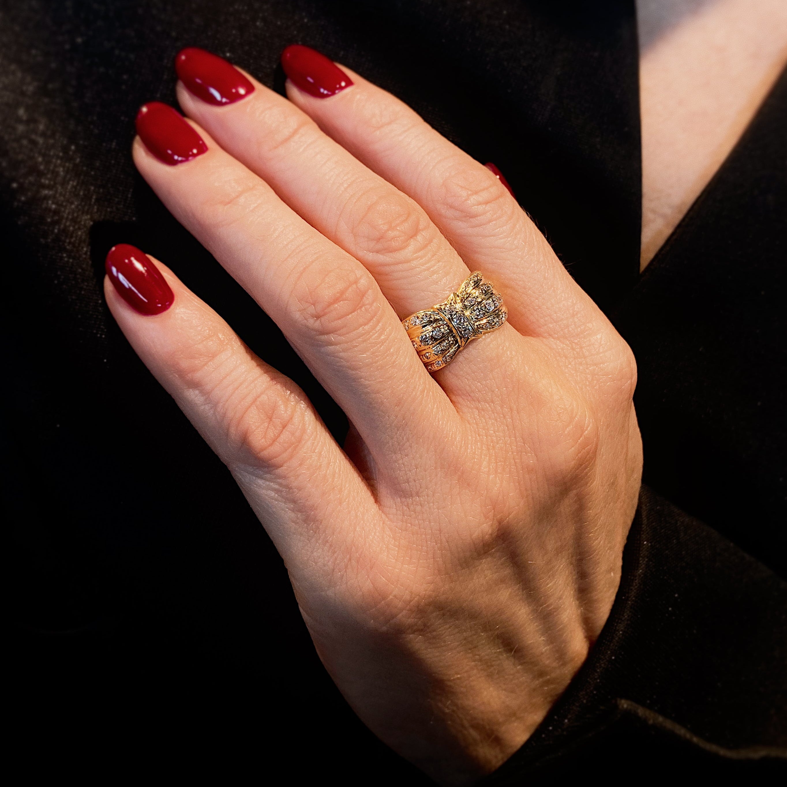 Woman wearing the Retro yellow gold diamond bow cocktail ring.