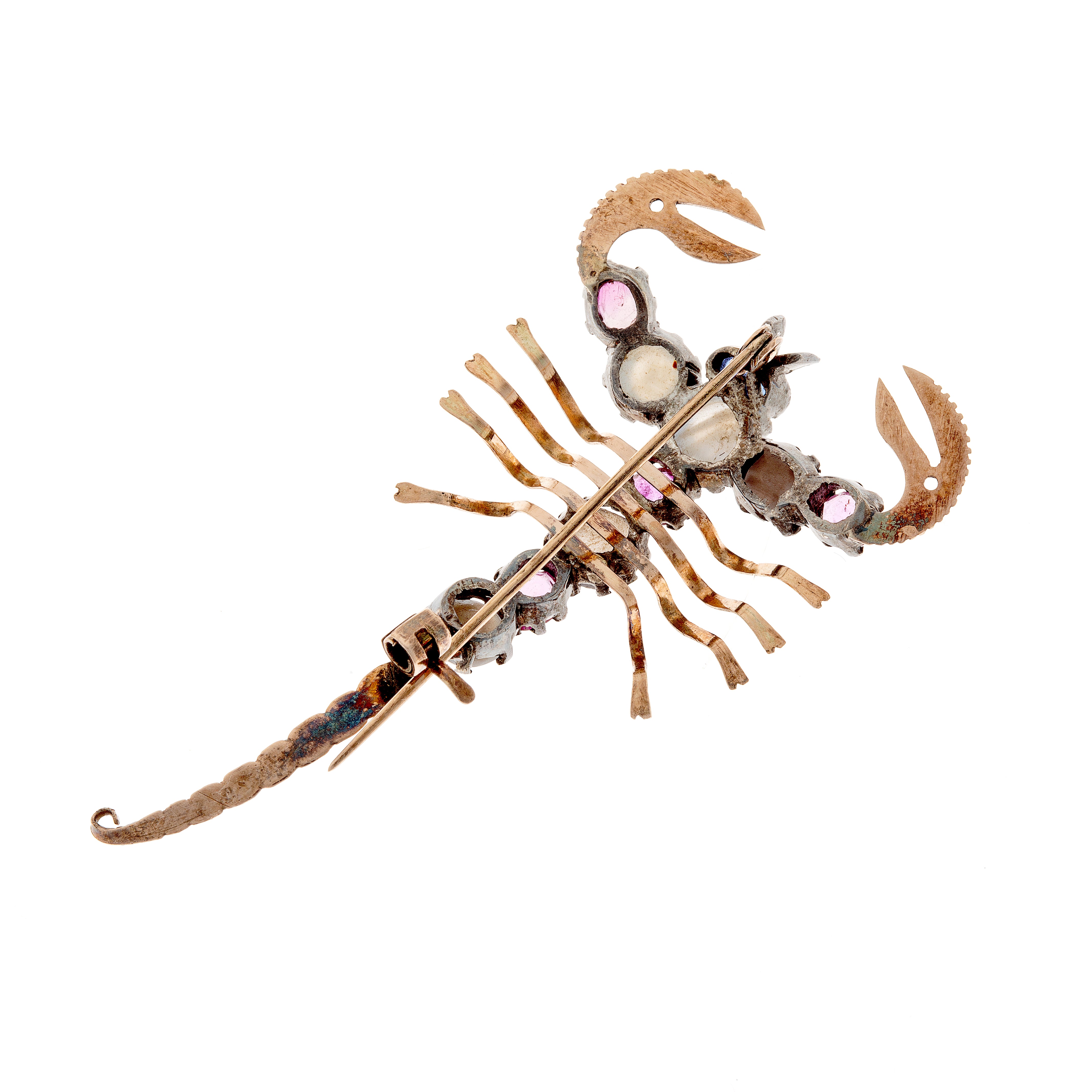 Back view of silver scorpion brooch with gold detailing, featuring five star sapphires and four rubies.