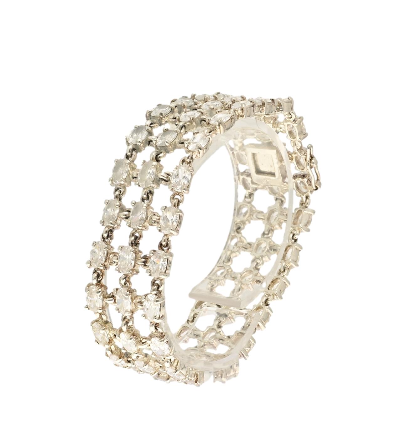 Wide vintage sterling silver tennis bracelet with three rows of faceted oval zircons in openwork setting.