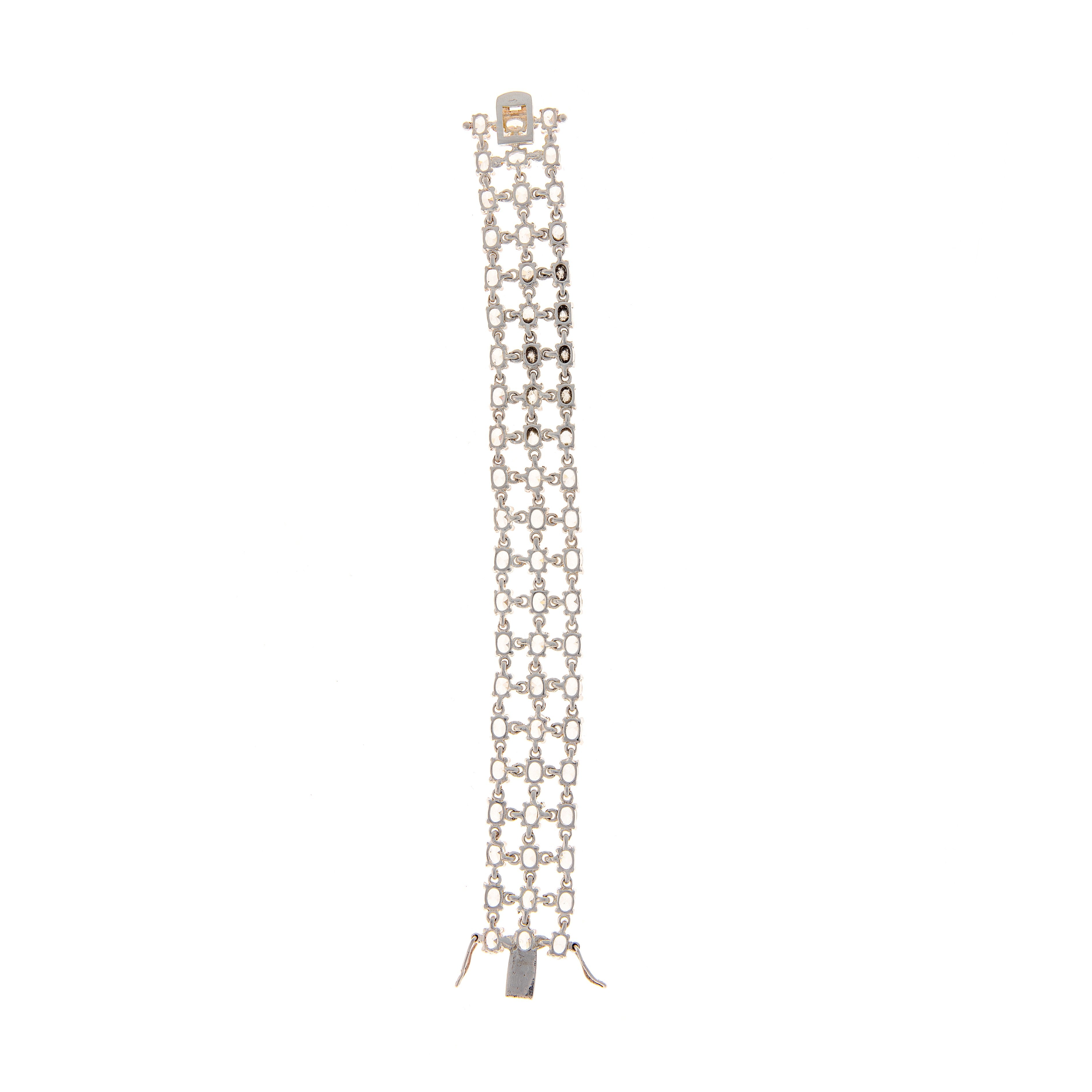 Extended flat back view of wide silver tennis bracelet featuring 63 oval-cut zircons in three rows.