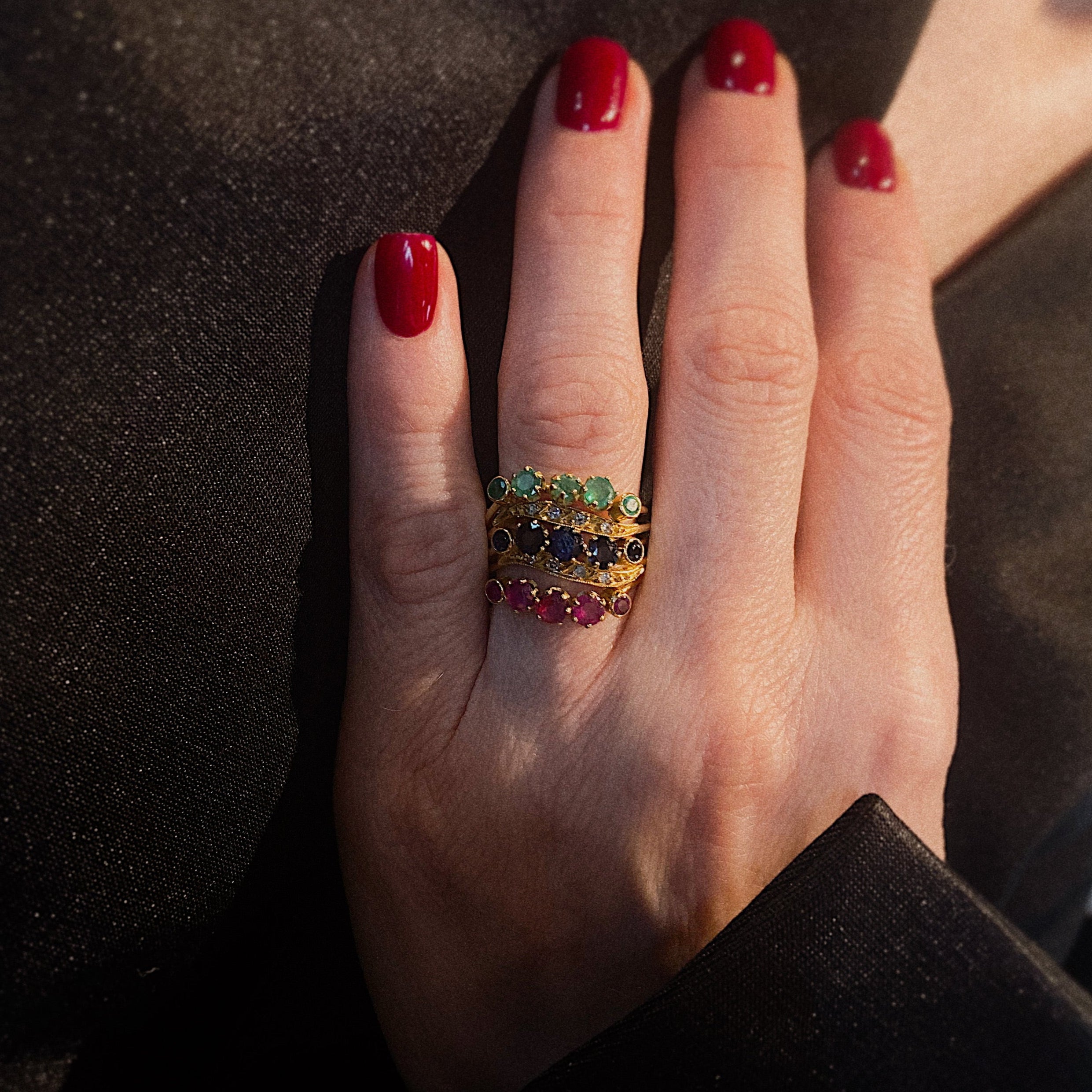 Model wearing the vintage gold statement ring with emeralds, sapphires, rubies and diamonds.