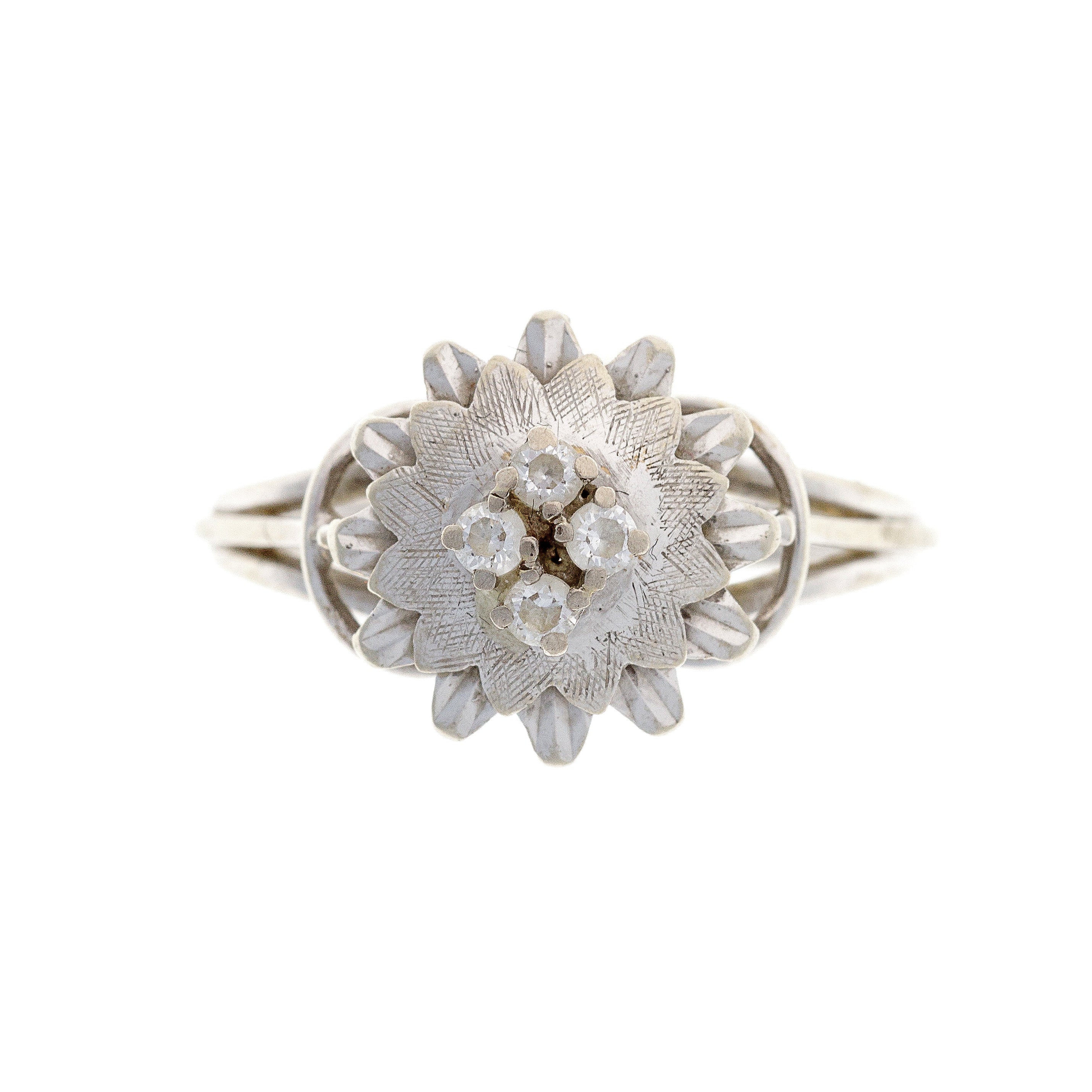 A vintage 18K white gold flower ring with cubic zirconia stones arranged in a floral-inspired petal design.