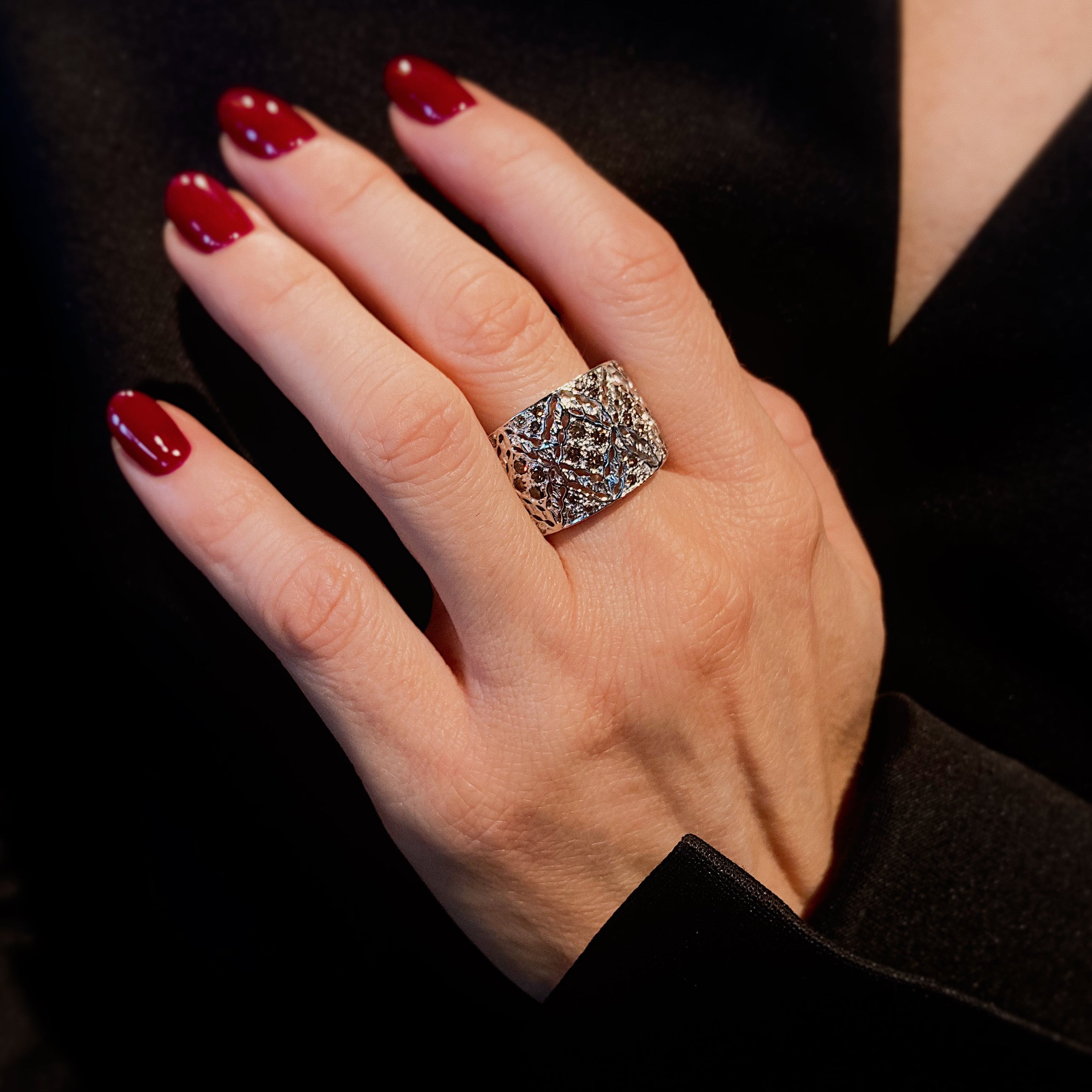 Woman wearing the Contemporary vintage wide openwork band ring with brown diamonds.