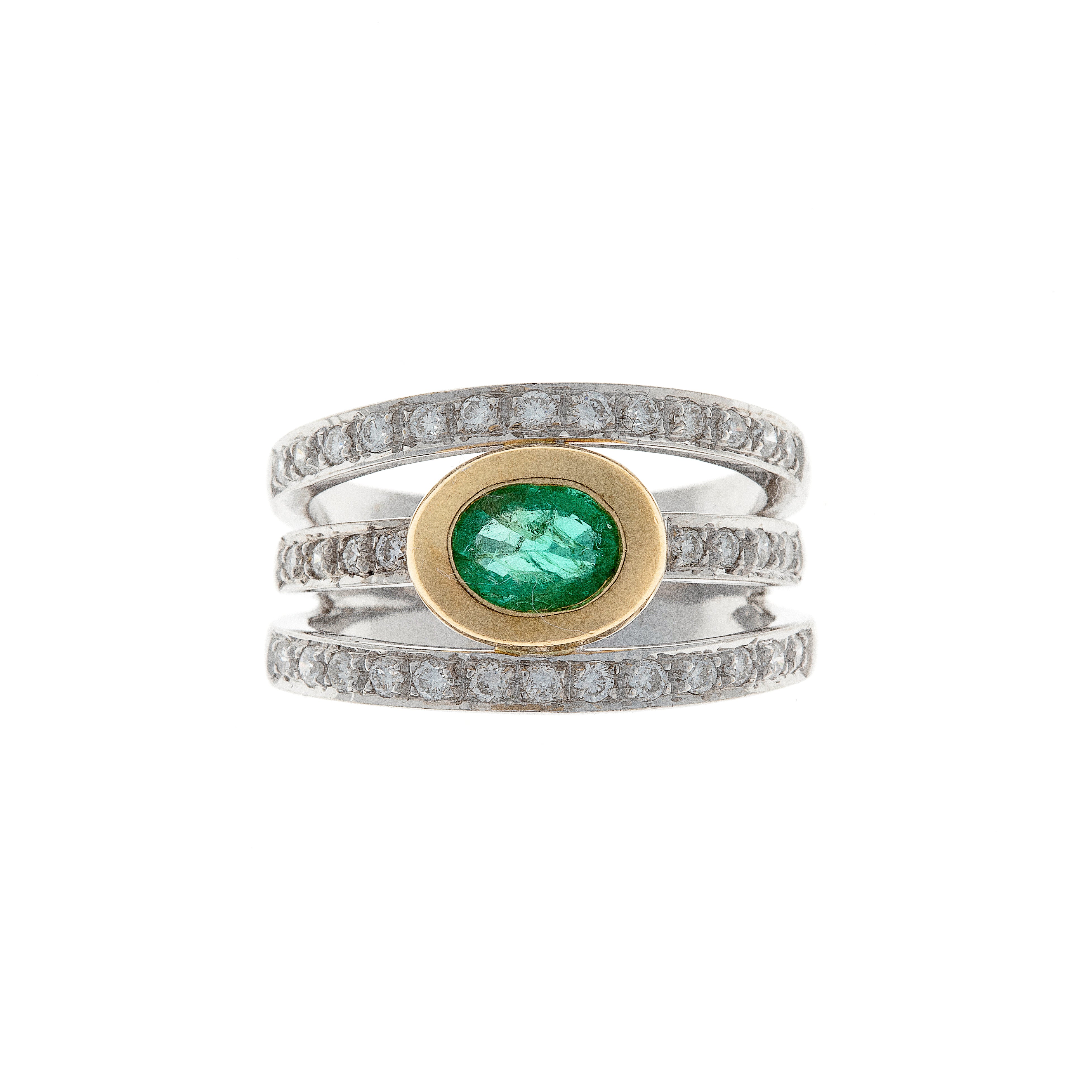 Vintage two-tone gold ring with oval-cut emerald and halo of brilliant-cut diamonds.