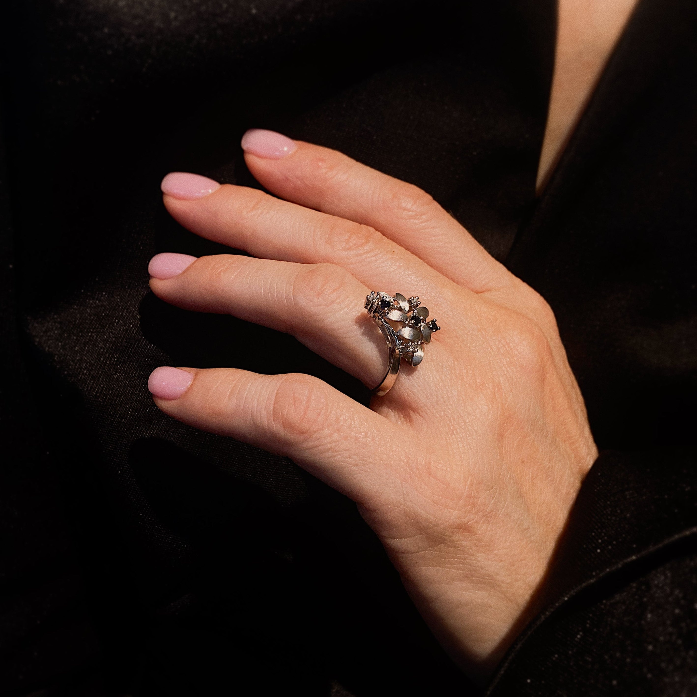 Woman model wearing the white gold floral vintage ring with sapphires and diamonds.