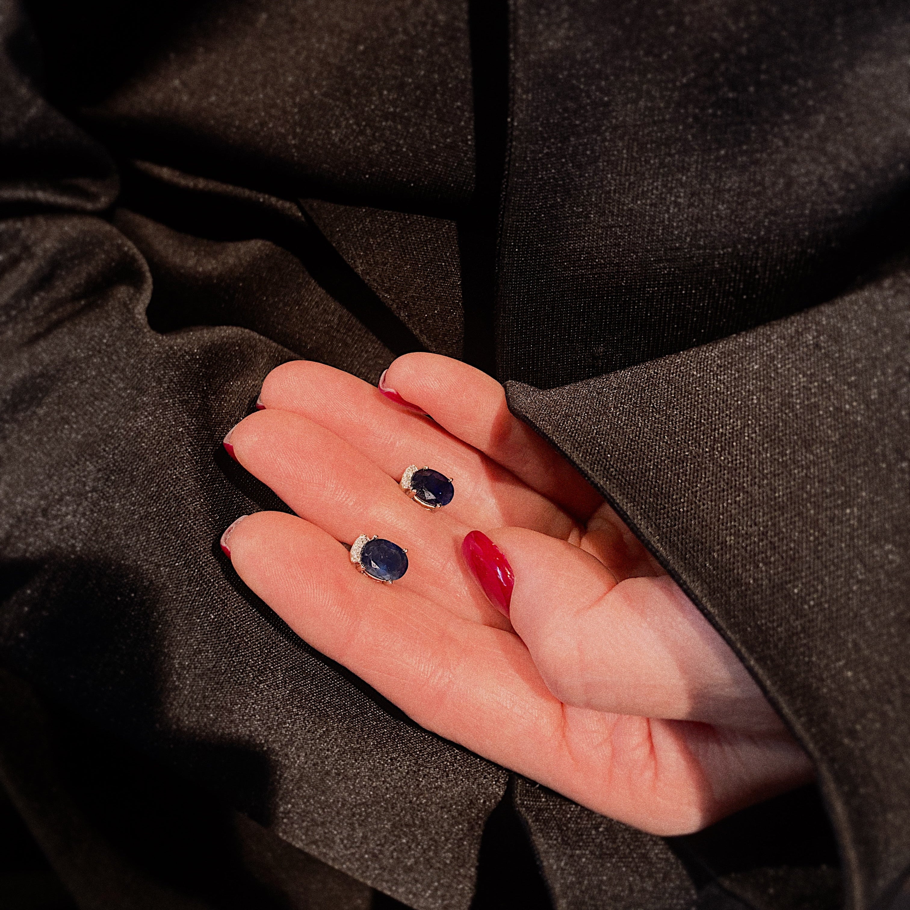 Model holding the vintage white gold sapphire and diamond earrings.